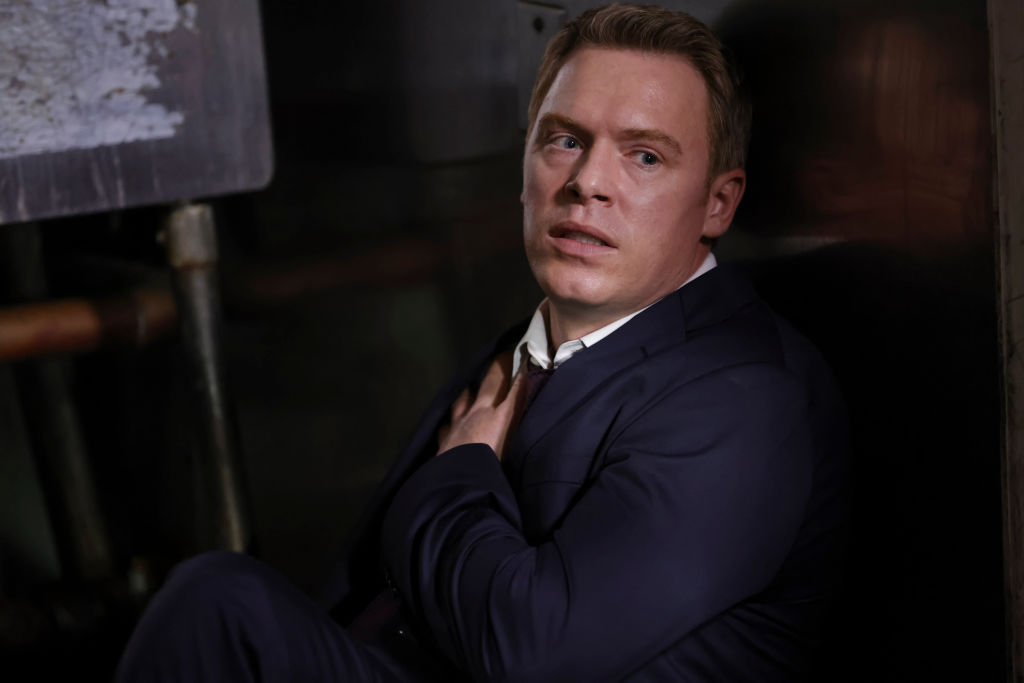 Diego Klattenhoff as Donald Ressler sits on the floor holding a bullet wound on his chest.