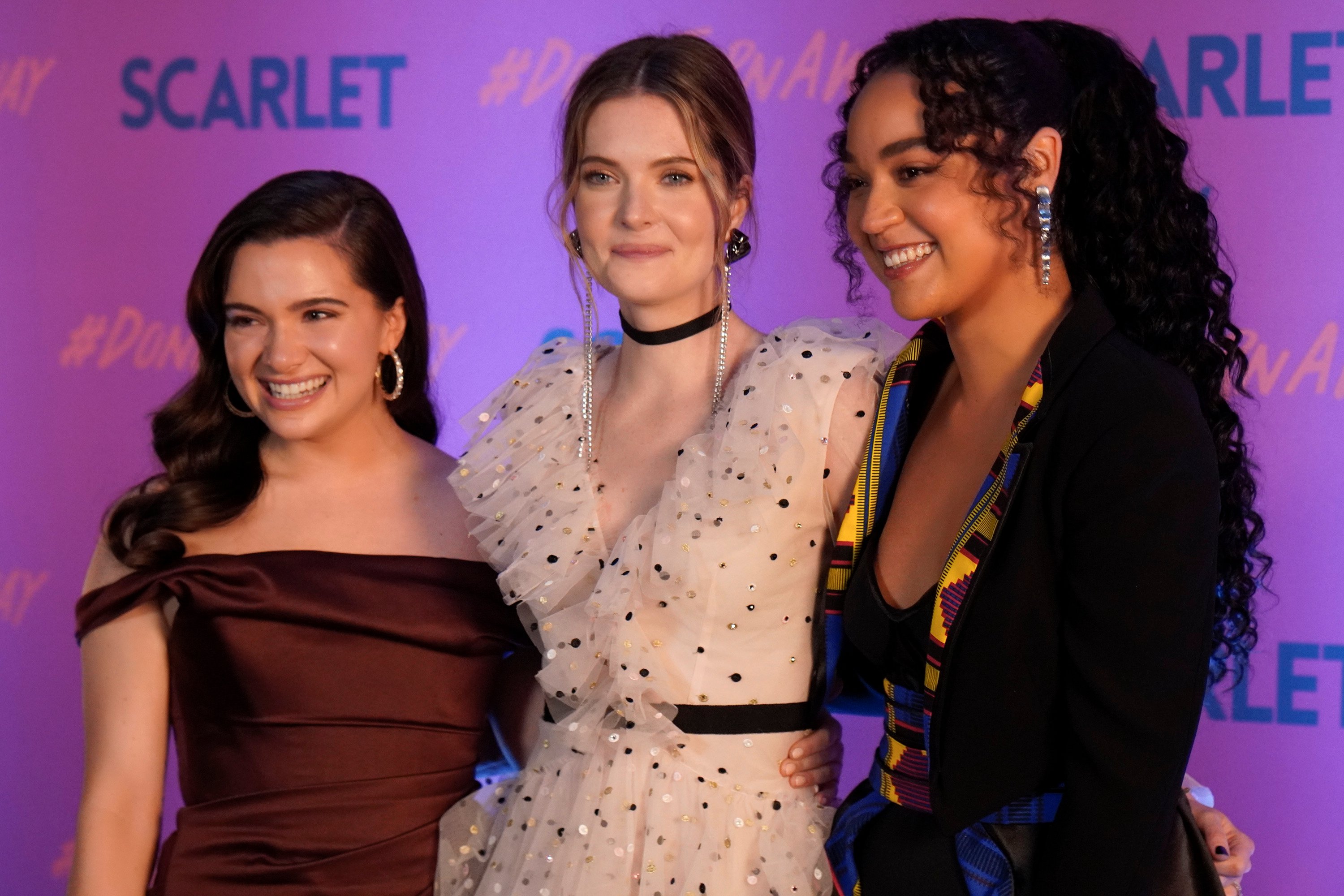 Jane, Sutton, and Kat smile in front of a backdrop for Scarlet Magazine in 'The Bold Type'