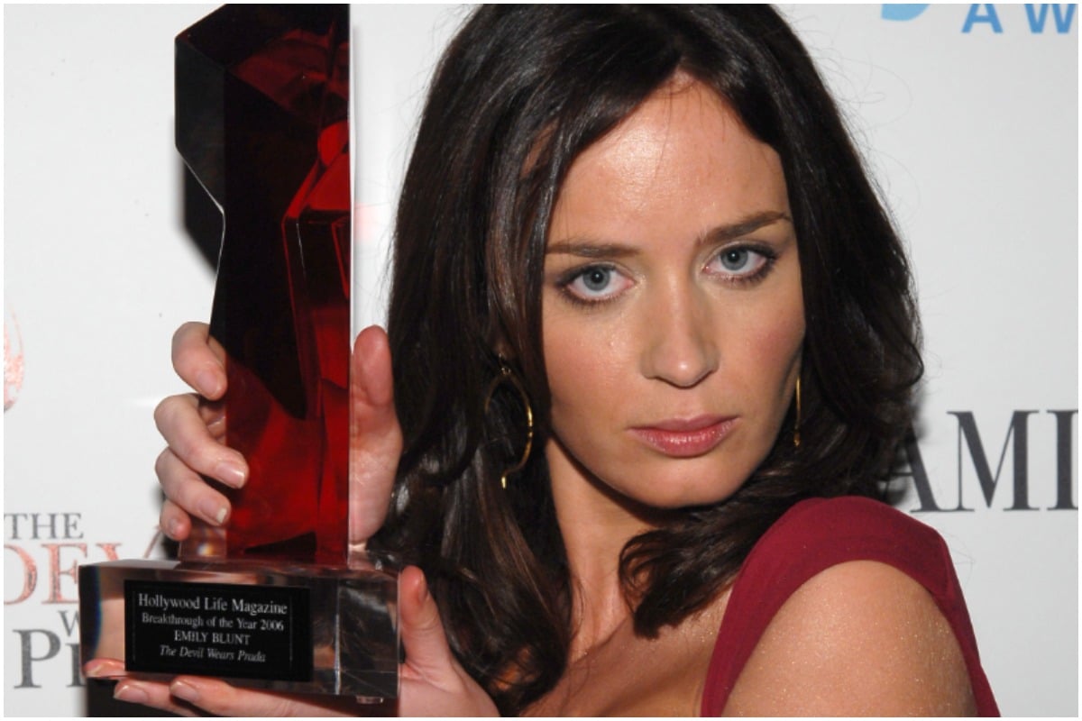 The Devil Wears Prada: Emily Blunt holding an award while wearing a red dress for her role as Emily.