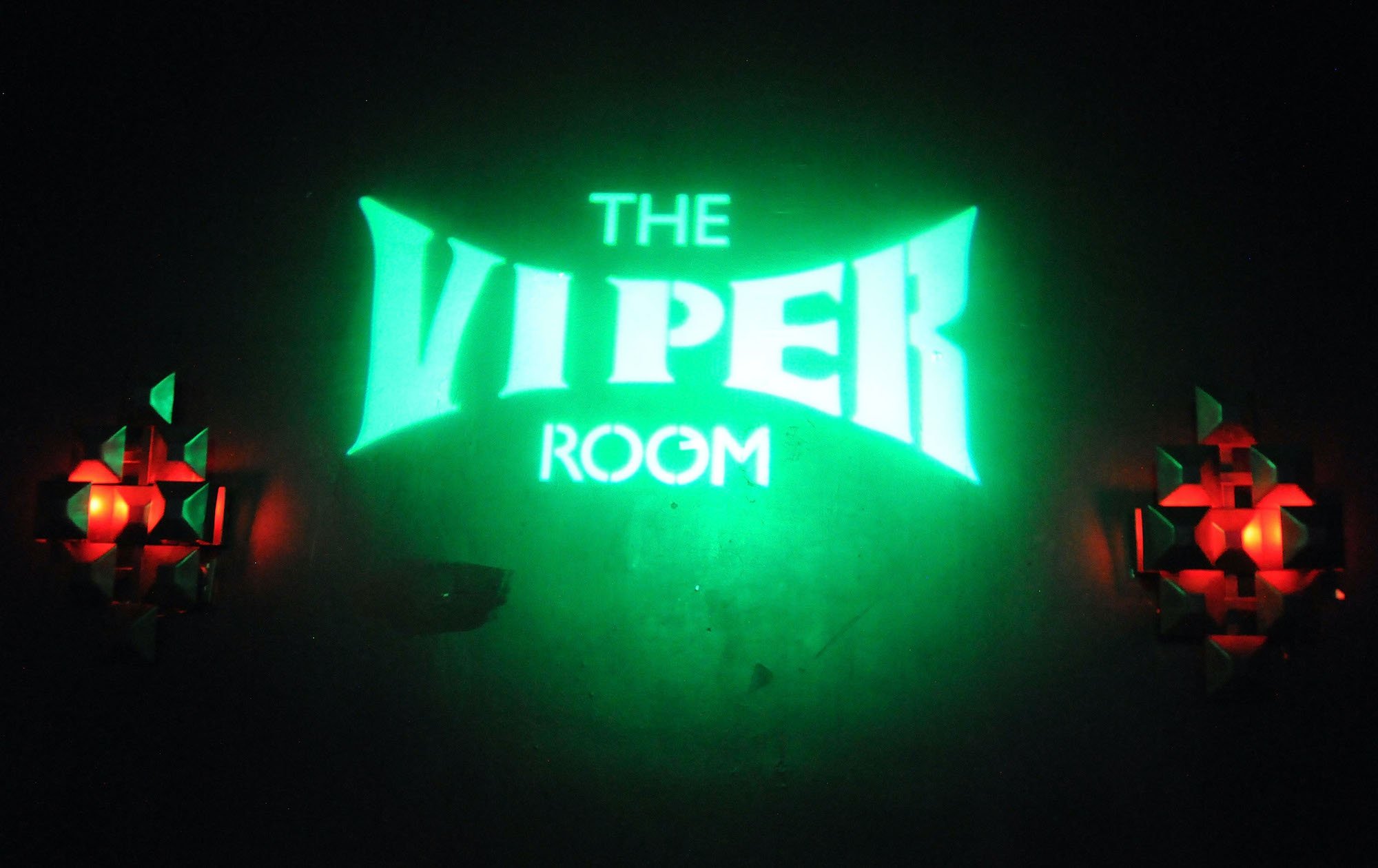 The Viper Room green neon sign lit in a dark room