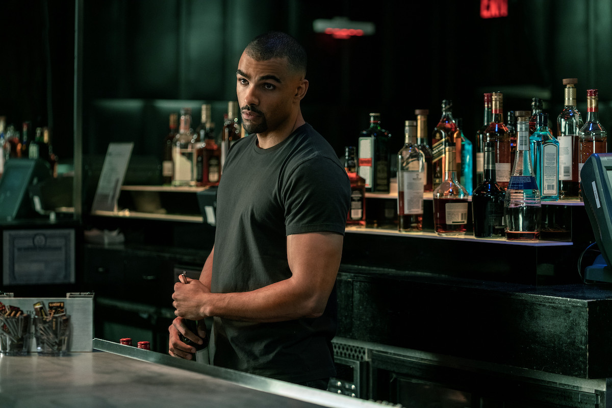 Toby Sandeman as Symphony Bosket standing behind a bar in 'Power Book III: Raising Kanan'