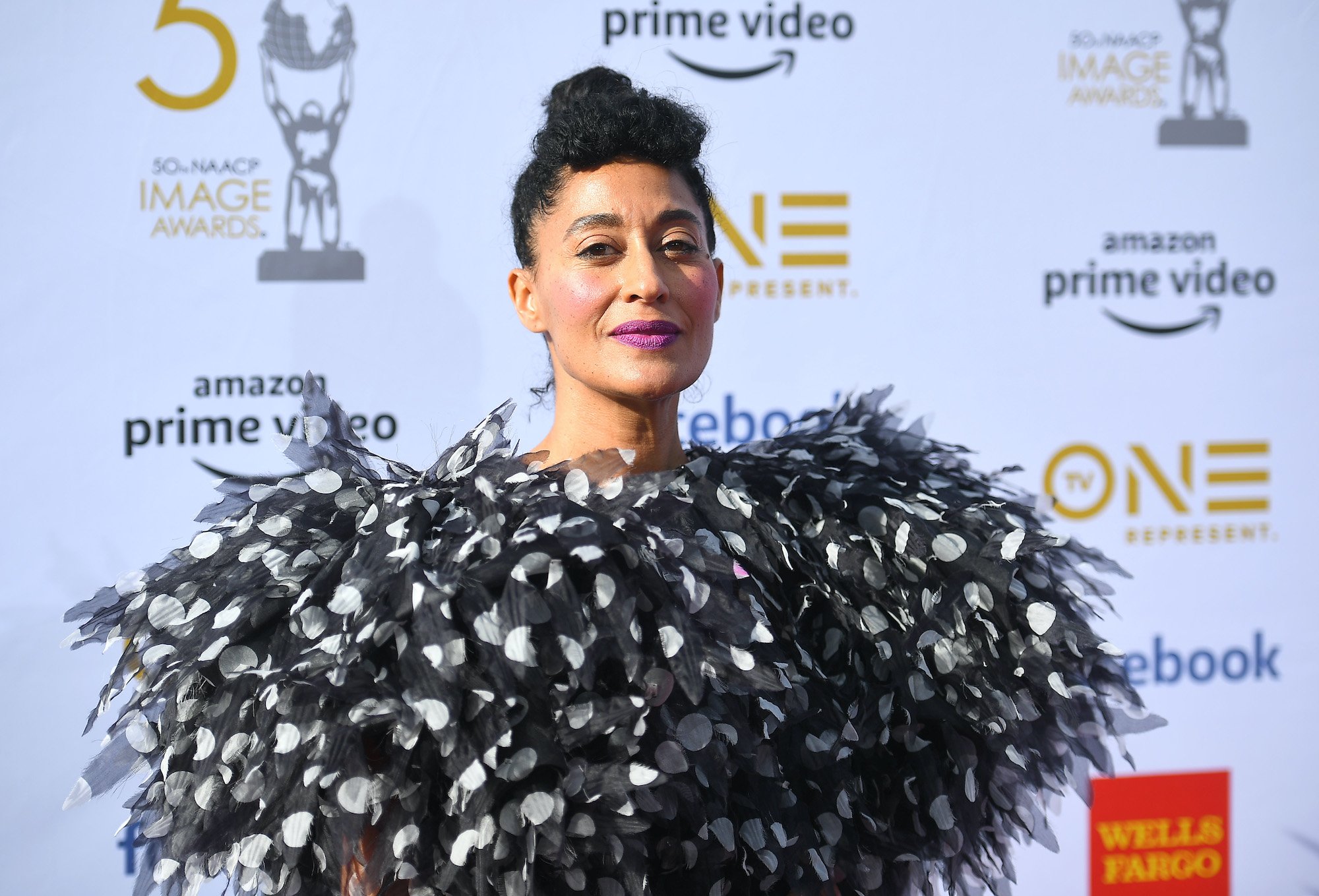 Tracee Ellis Ross smiling in front of a white background