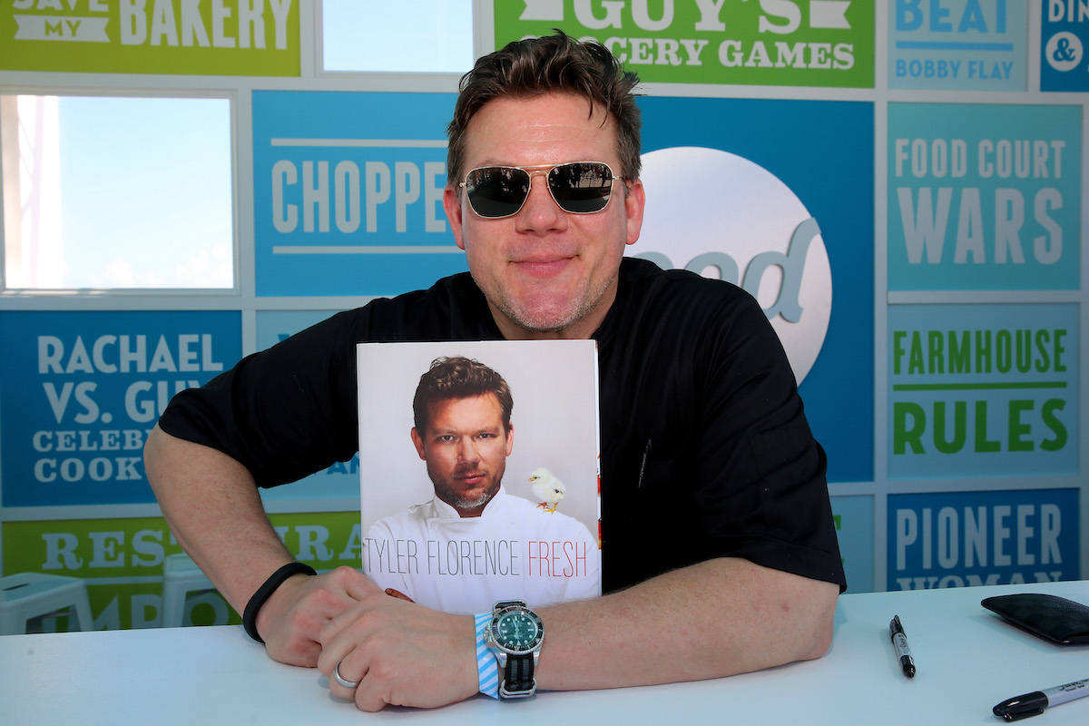 Tyler Florence poses with a copy of his cookbook at the 2014 Food Network South Beach Wine and Food Festival