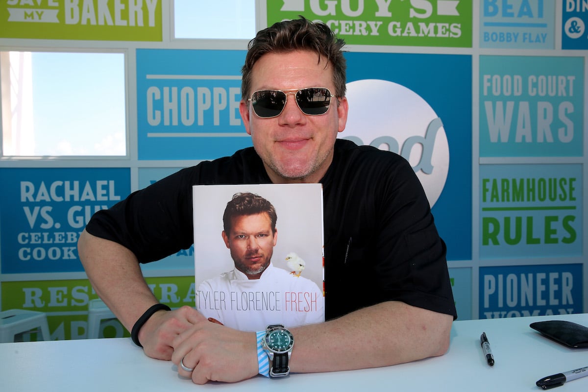 Tyler Florence poses with a copy of his cookbook at the 2014 Food Network South Beach Wine and Food Festival
