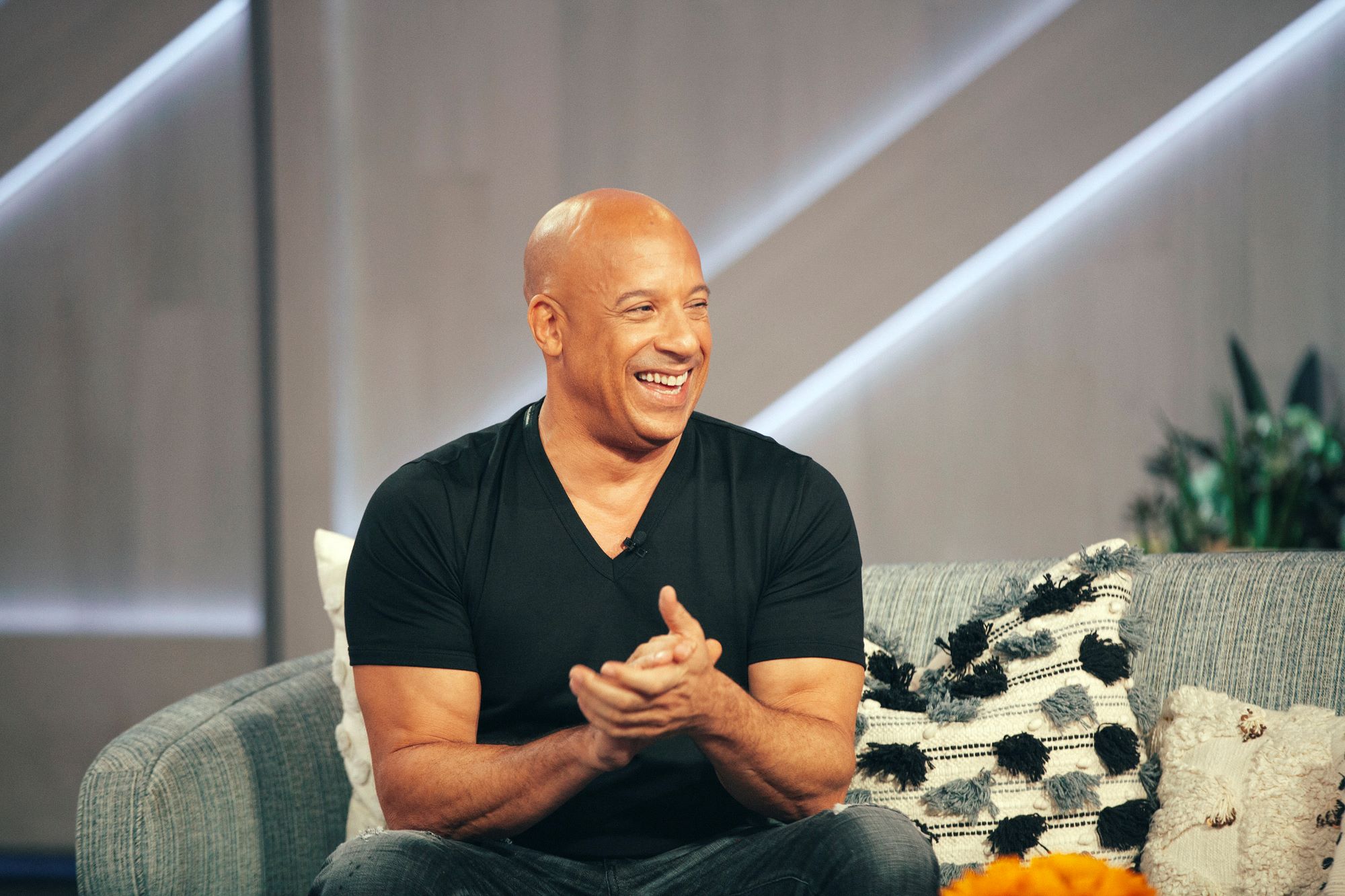 Vin Diesel sitting on a couch on the set of a talk show