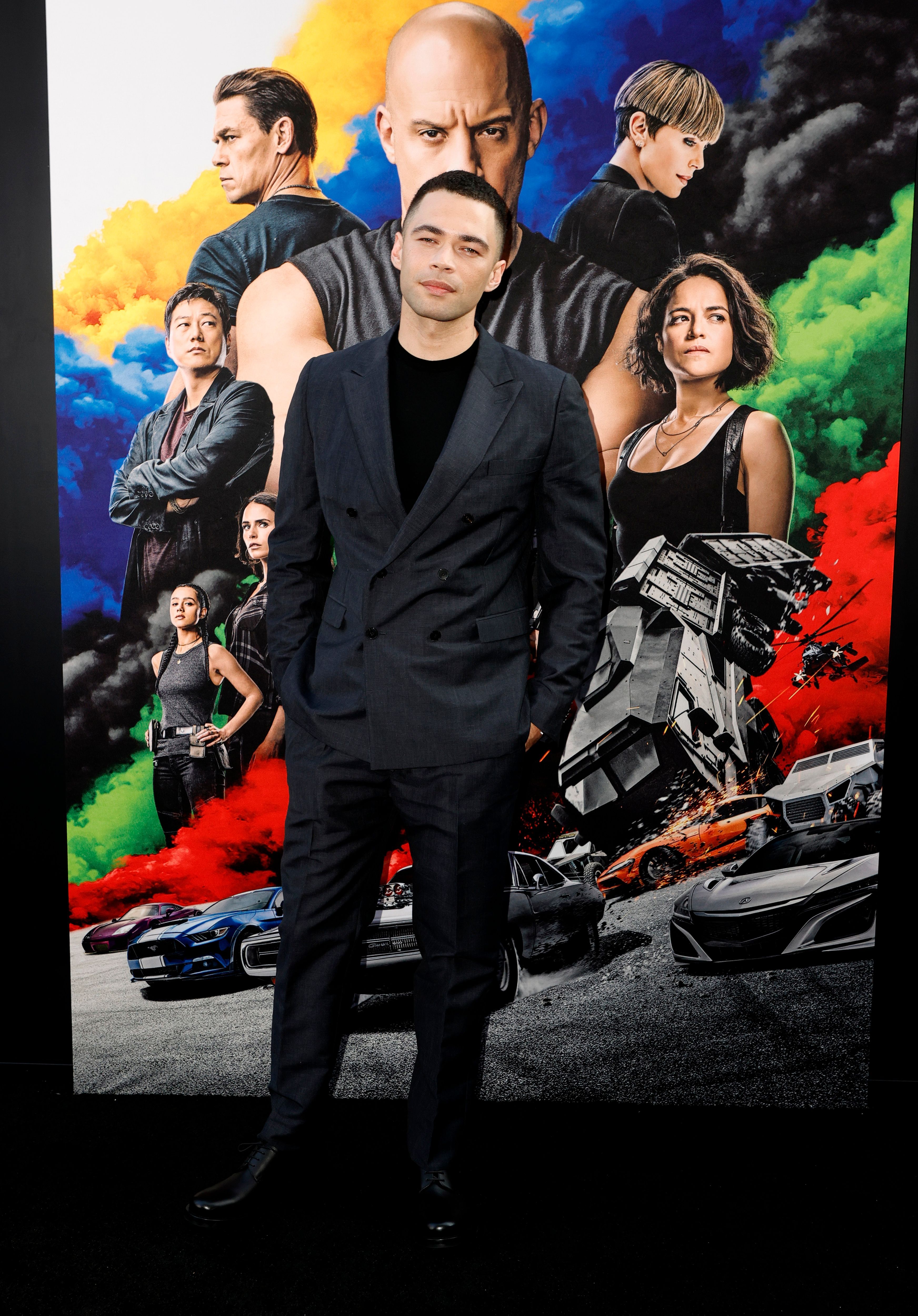 Vinnie Bennett stands in front of the 'F9' poster