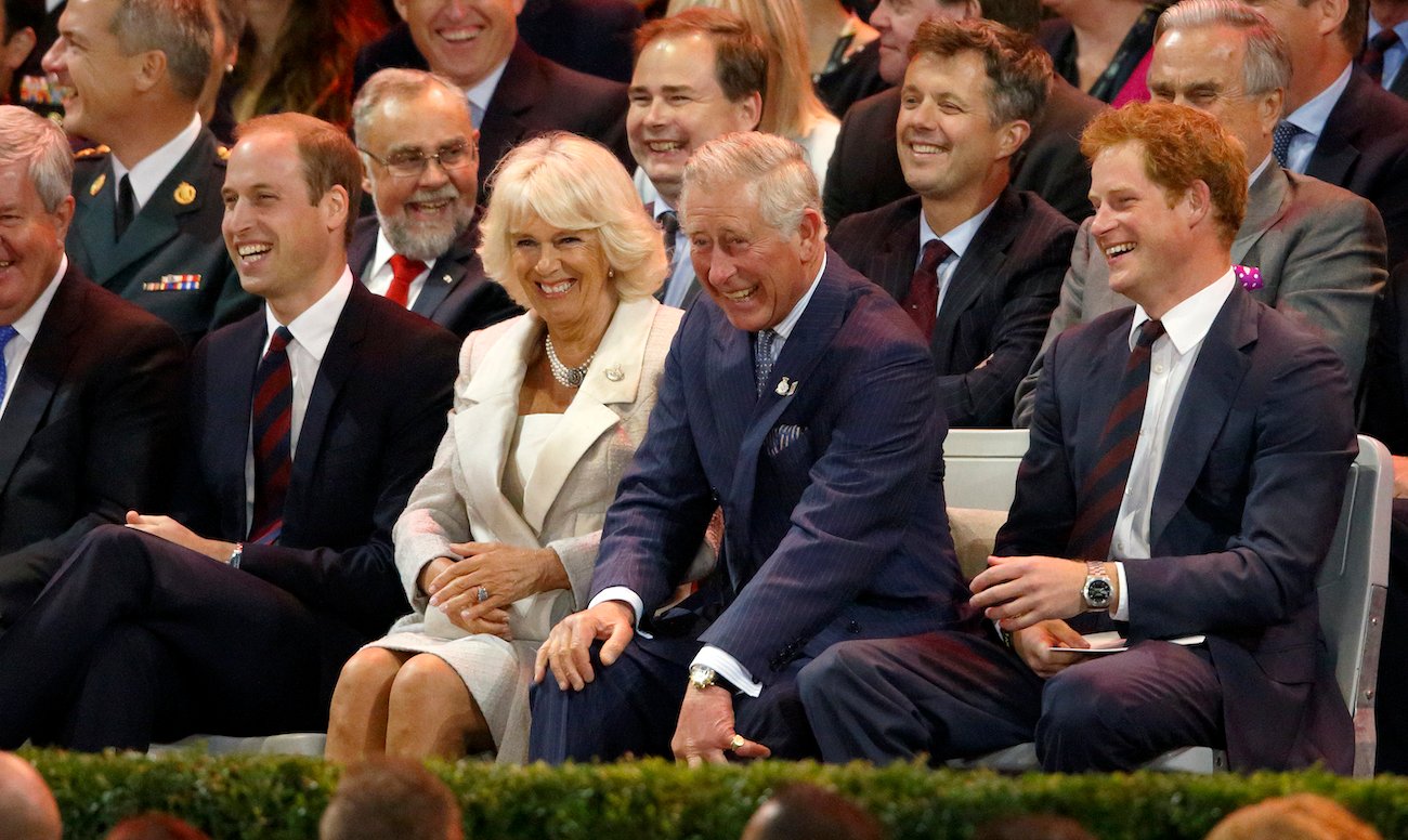 Prince William, Camilla Parker Bowles, Prince Charles, and Prince Harry sitting next to each other and laughing