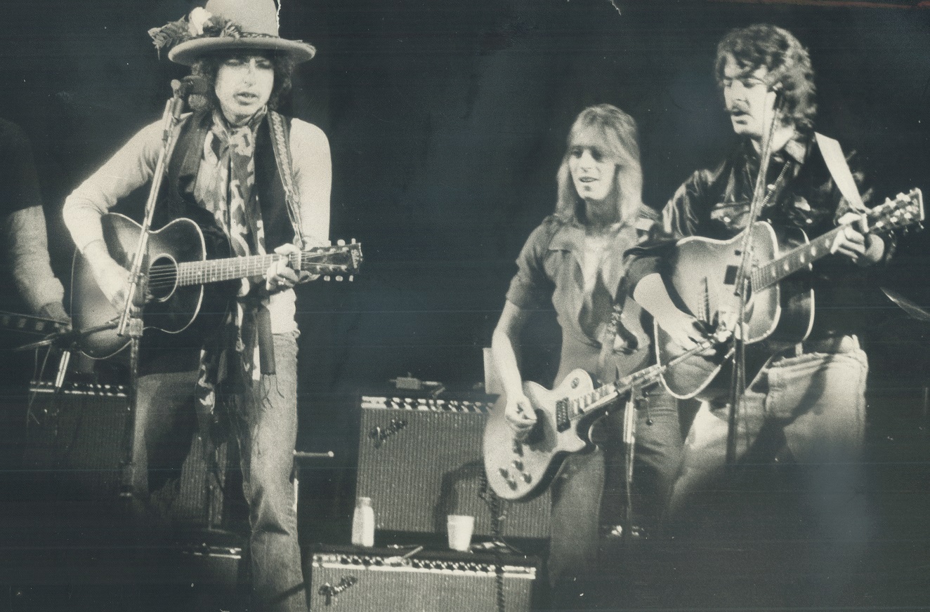 Bob Dylan and other musicians perform on stage in 1975.