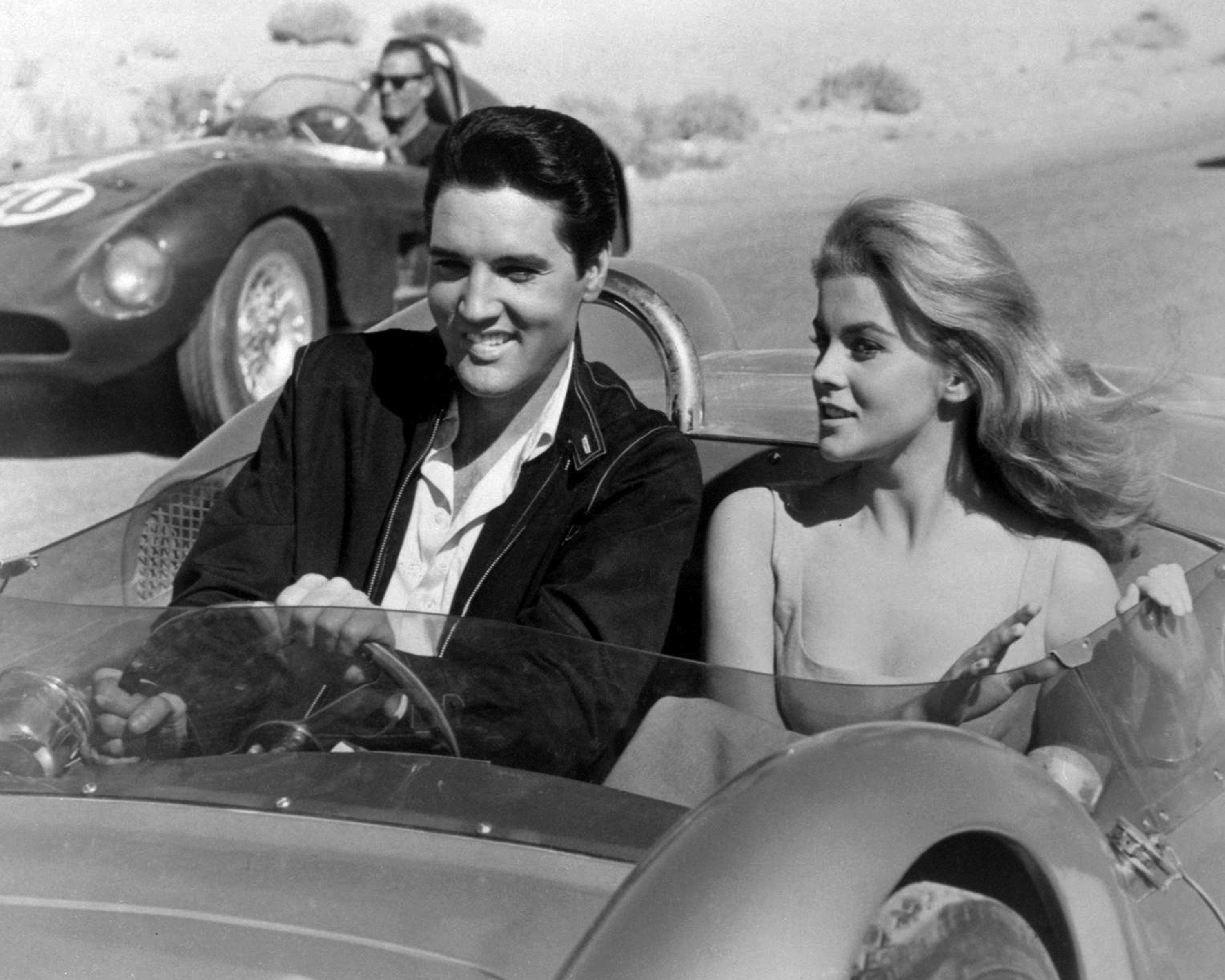 Elvis Presley driving a car with Ann-Margret in the passenger seat