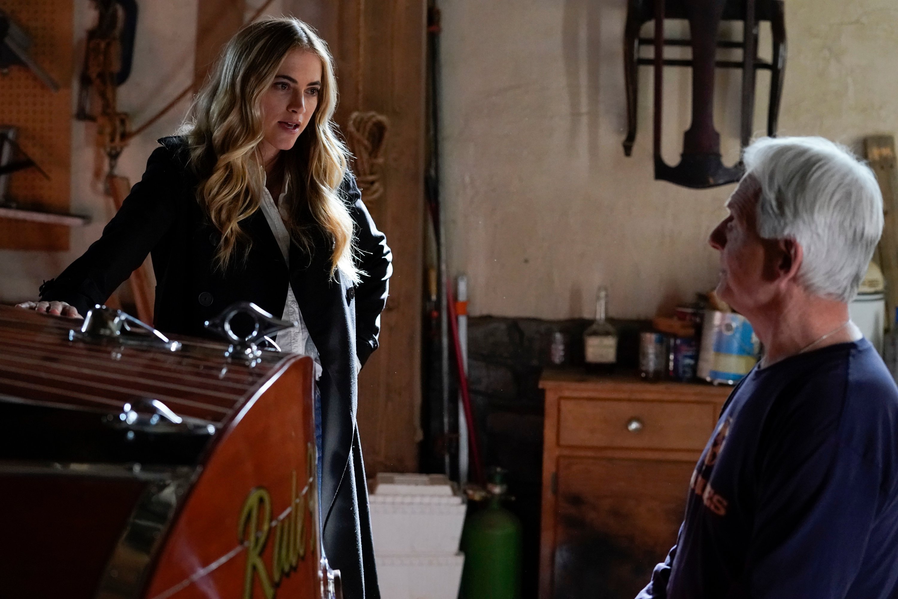 Emily Wickersham and Mark Harmon talk in Gibbs' basement on the set of NCIS.