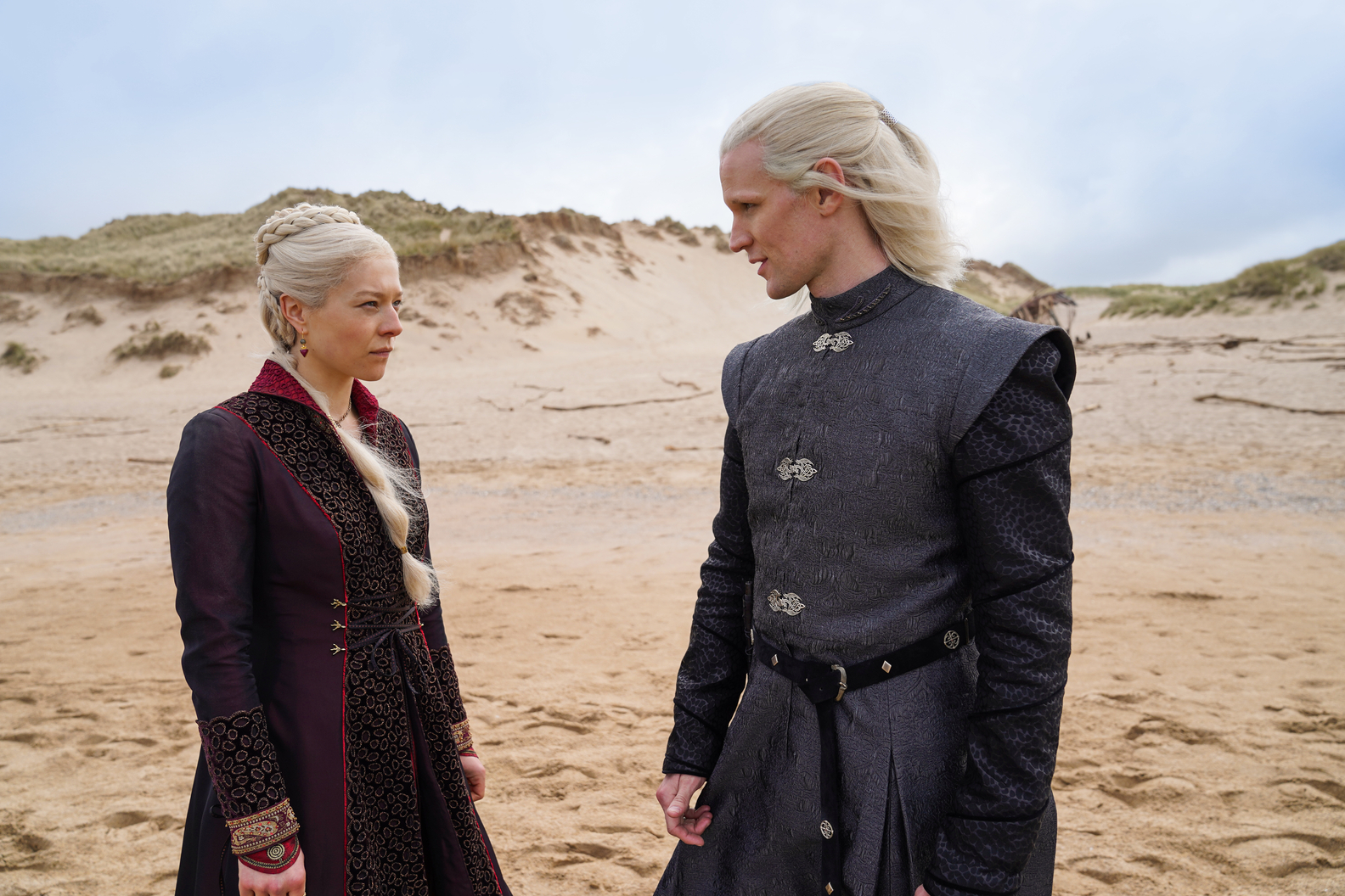 Emma D’Arcy and Matt Smith wearing blonde wigs and standing in a desert landscape in HBO's 'House of the Dragon'