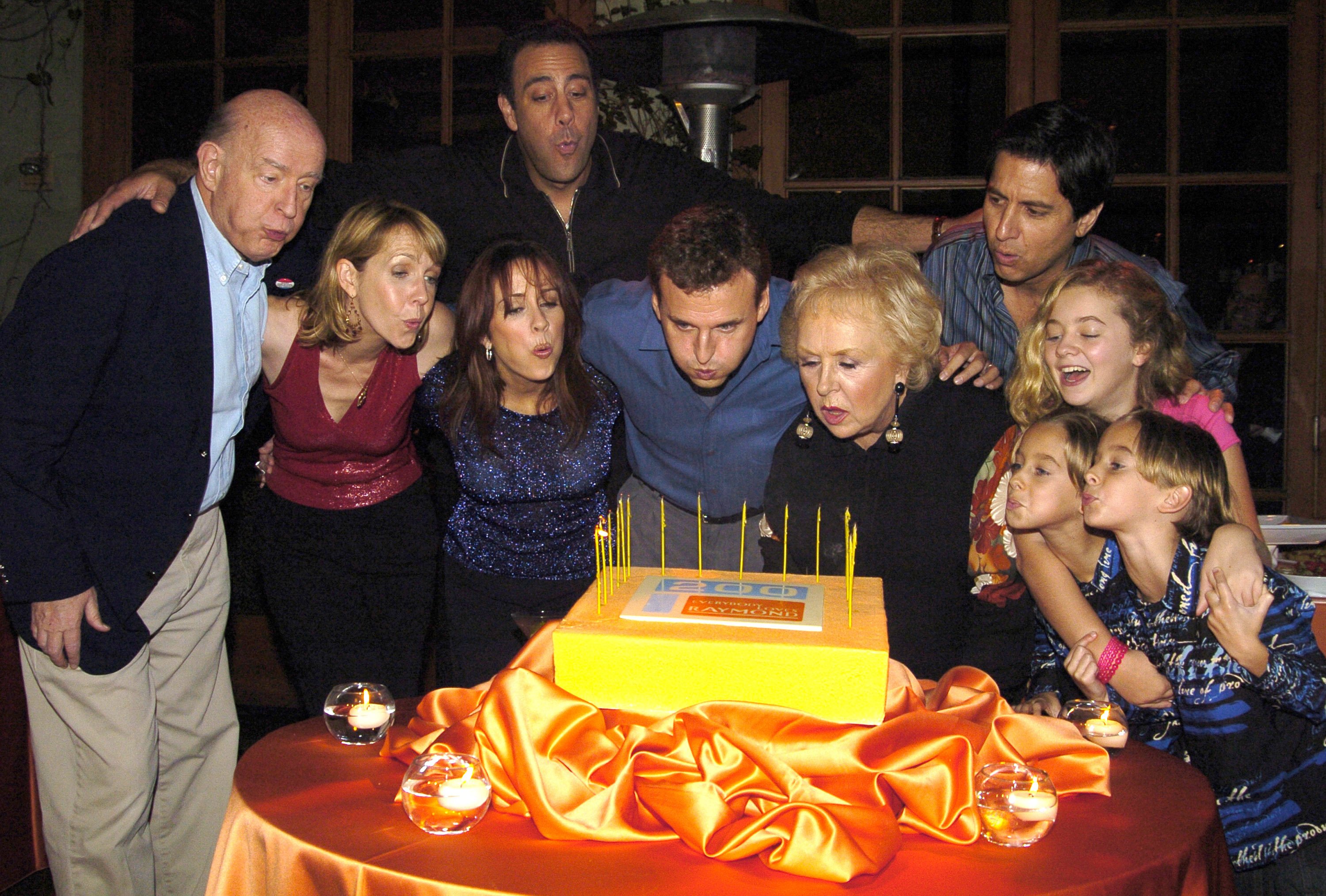 'Everybody Loves Raymond' executive producer Phil Rosenthal (center) and the show's cast blow out candles on a cake celebrating the comedy's 200th episode in 2004.
