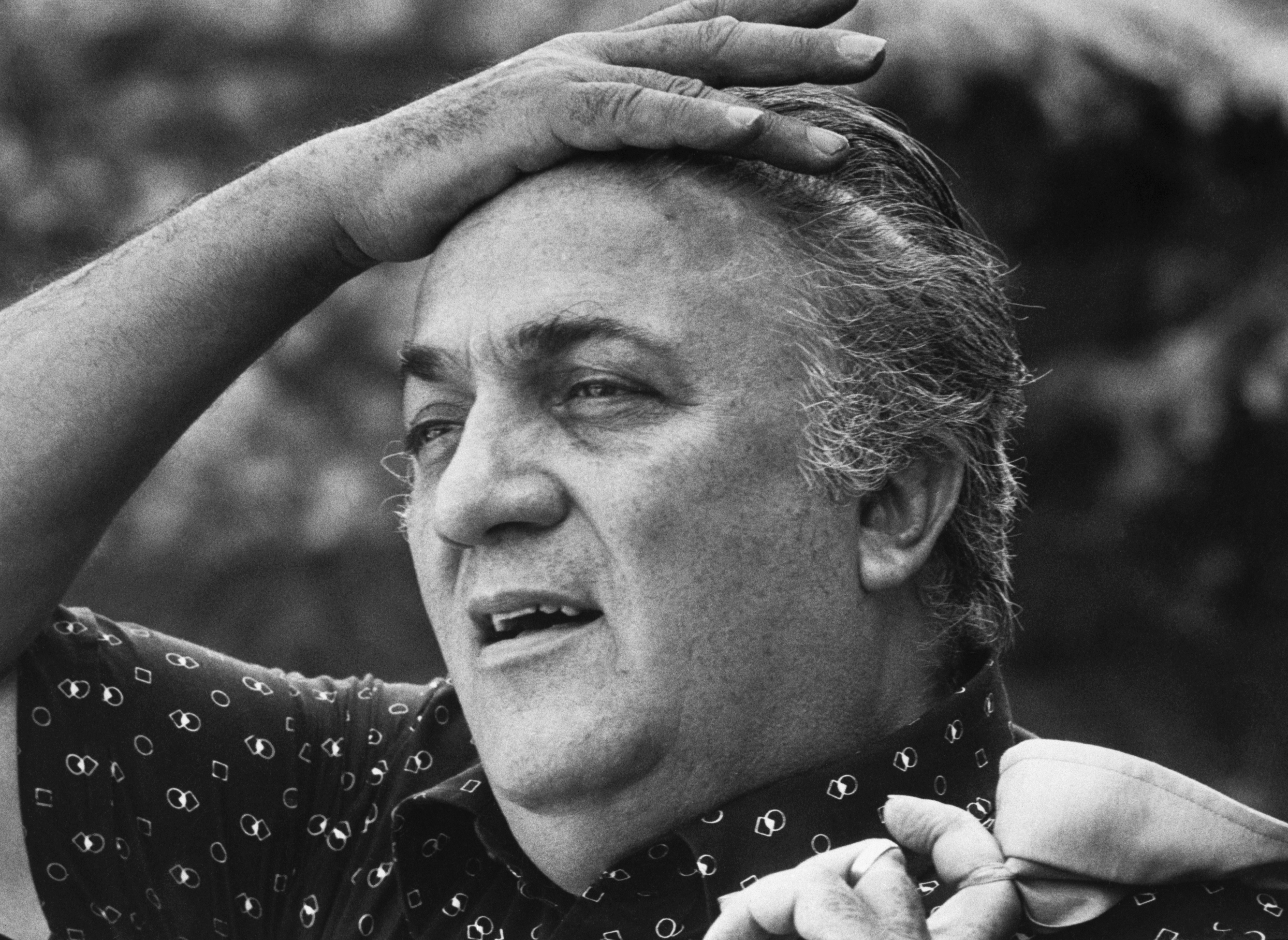 Federico Fellini with his hand on his head
