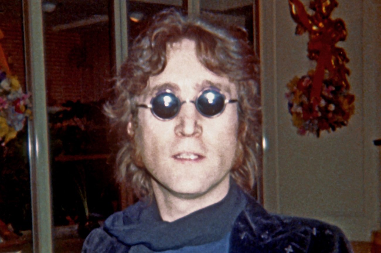 John Lennon, wearing sunglasses, stares at the camera in 1974.