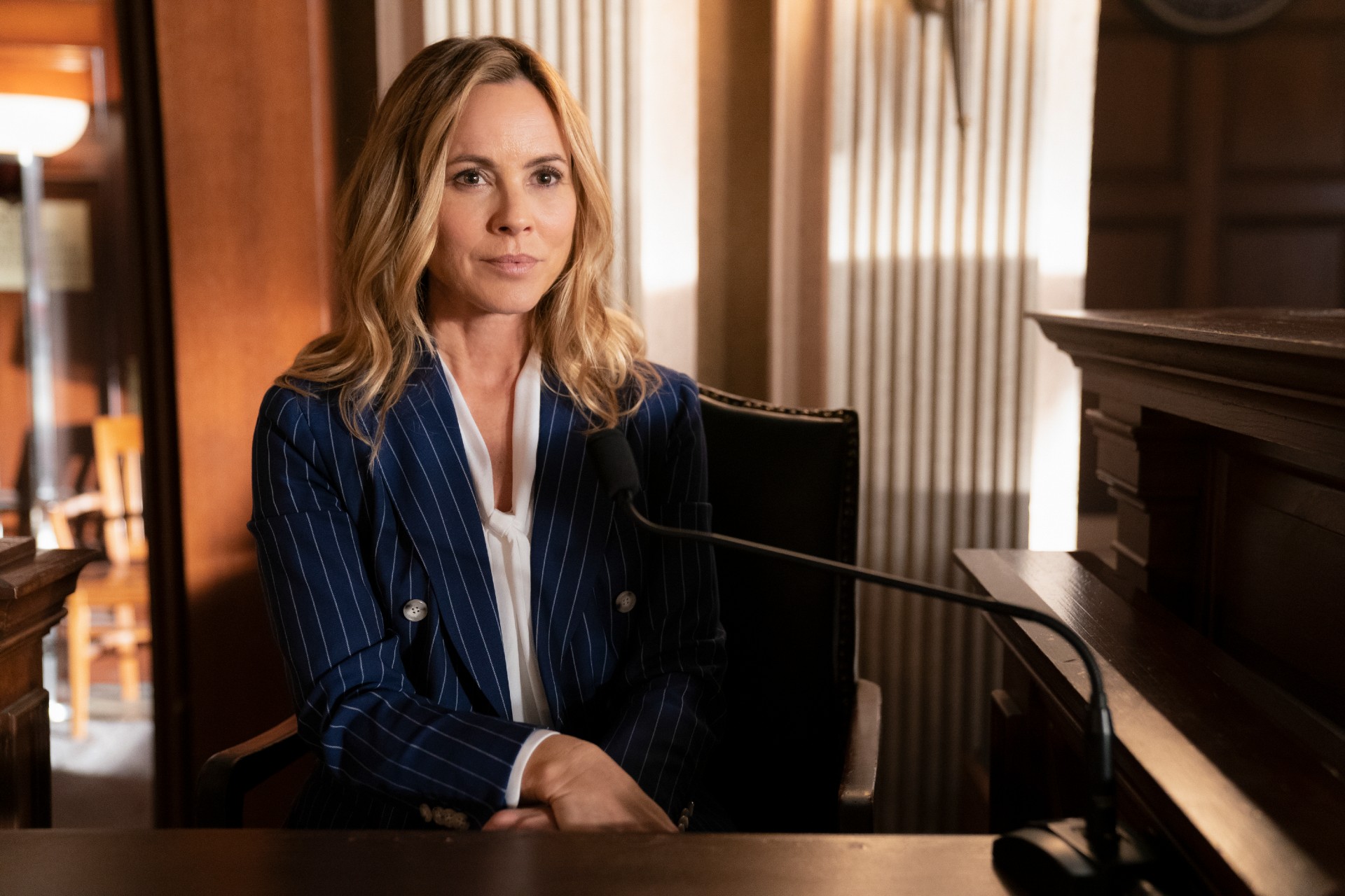Maria Bello sits on the stand during a court scene