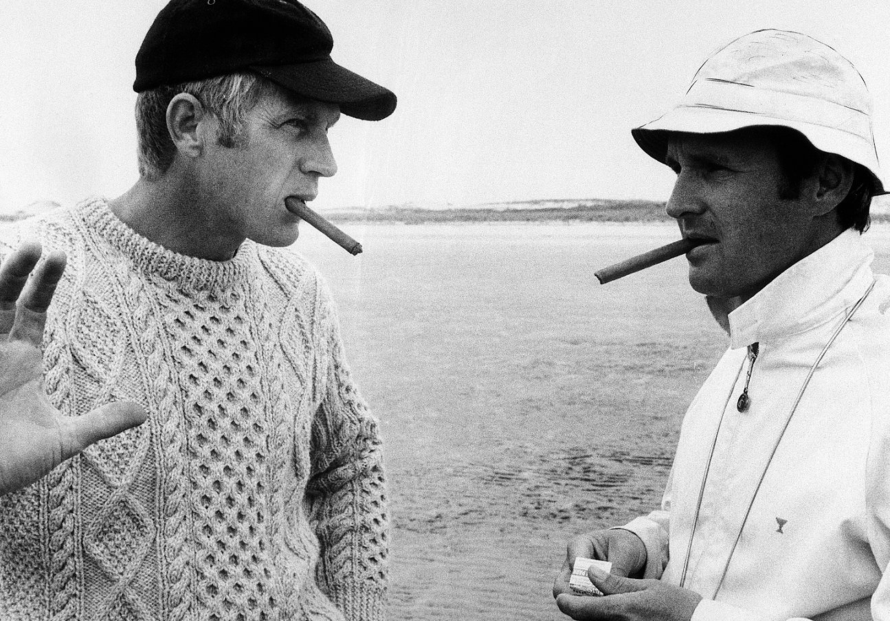 Steve McQueen and Norman Jewison, both smoking cigars, confer on location  during the 'Thomas Crown Affair' shoot.