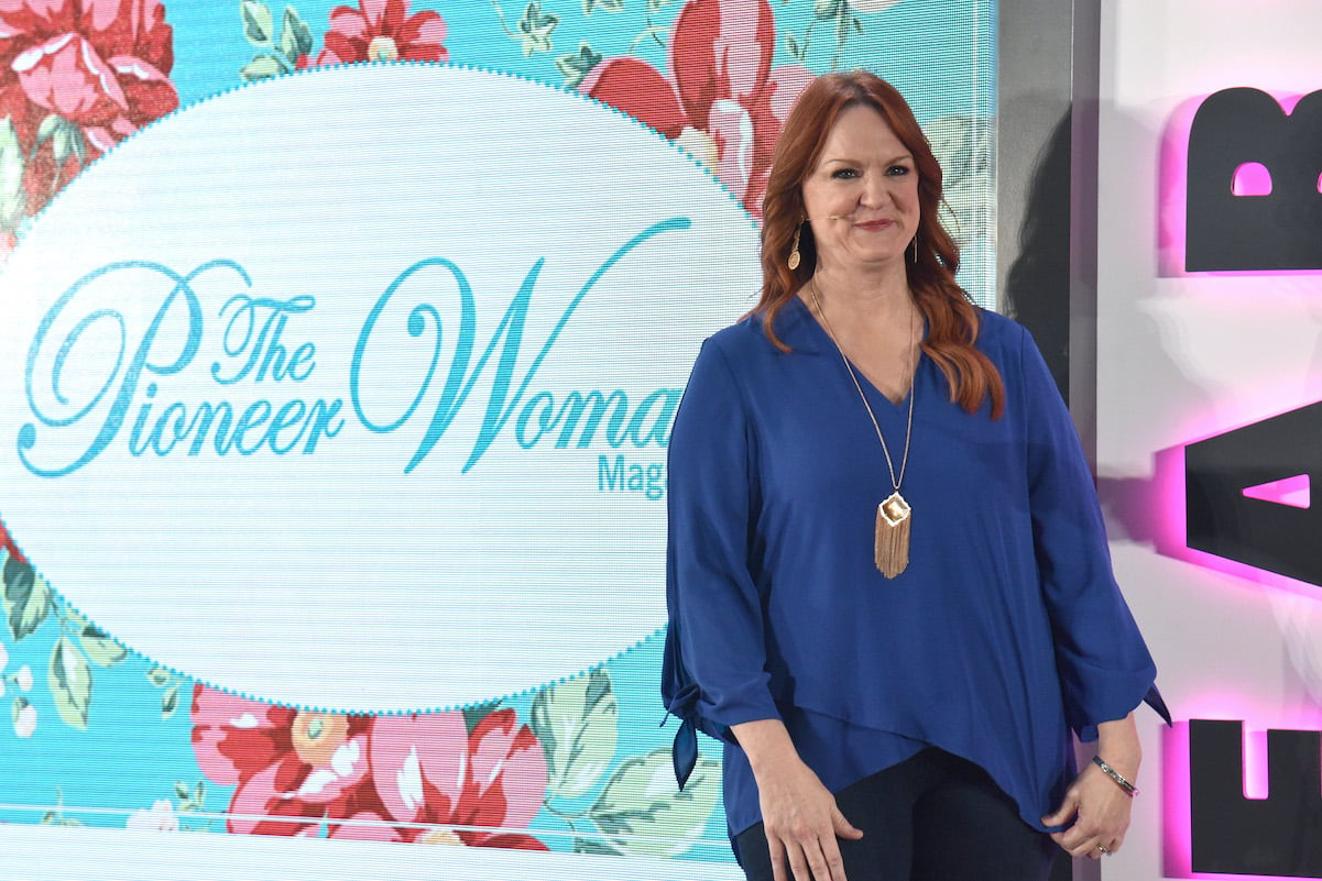 Ree Drummond smiles in front of Pioneer Woman magazine backdrop