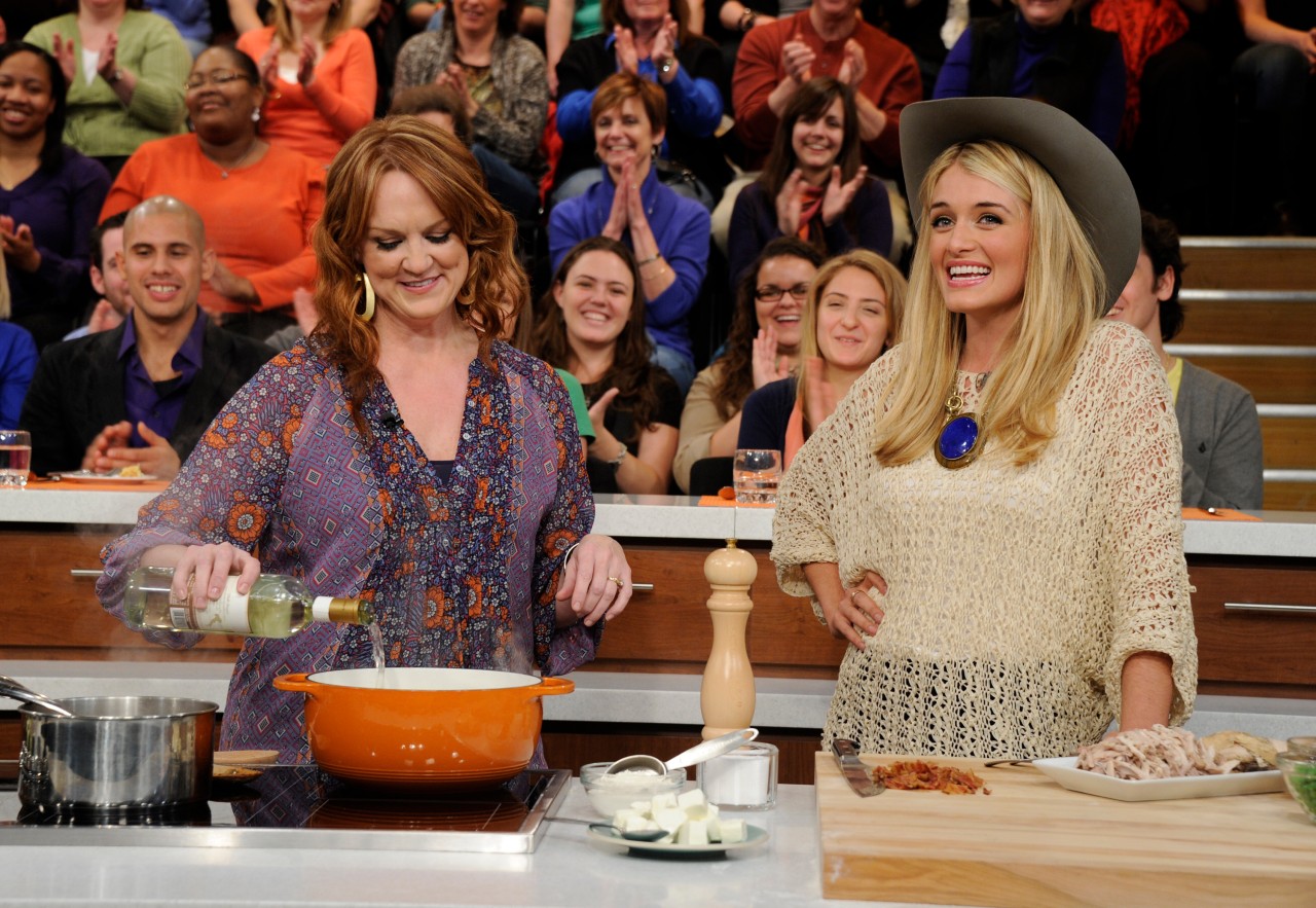 Ree Drummond stirs a meal in an orange pot while talking with Daphne Oz on 'The Chew' television show.