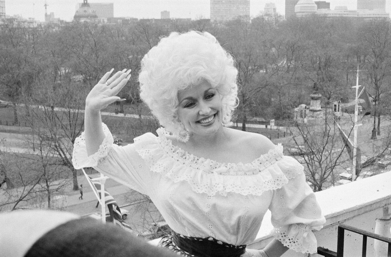 Dolly Parton waves to the camera in London in 1983.