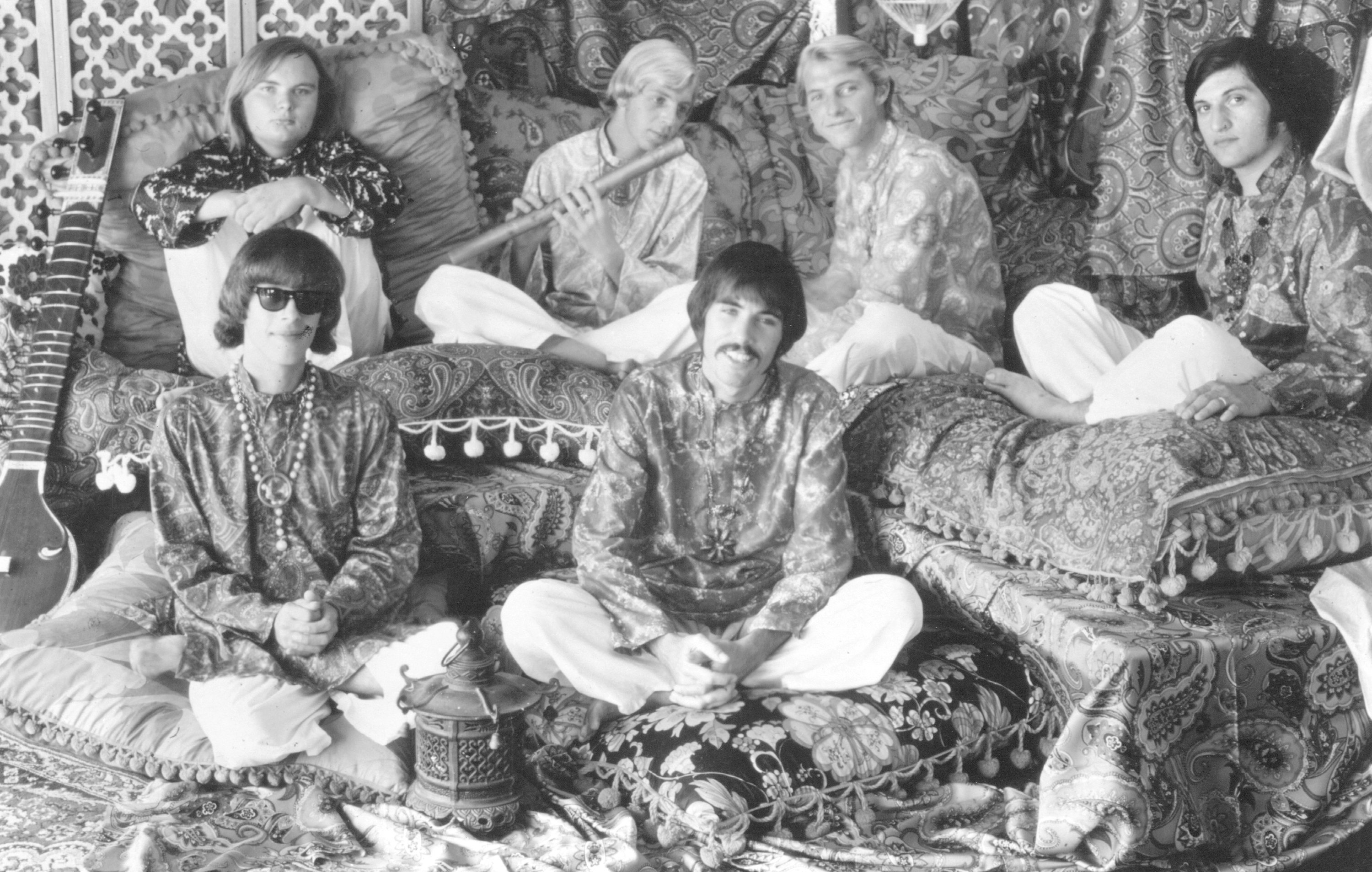 Members of Strawberry Alarm Clock sitting on ornate cushions