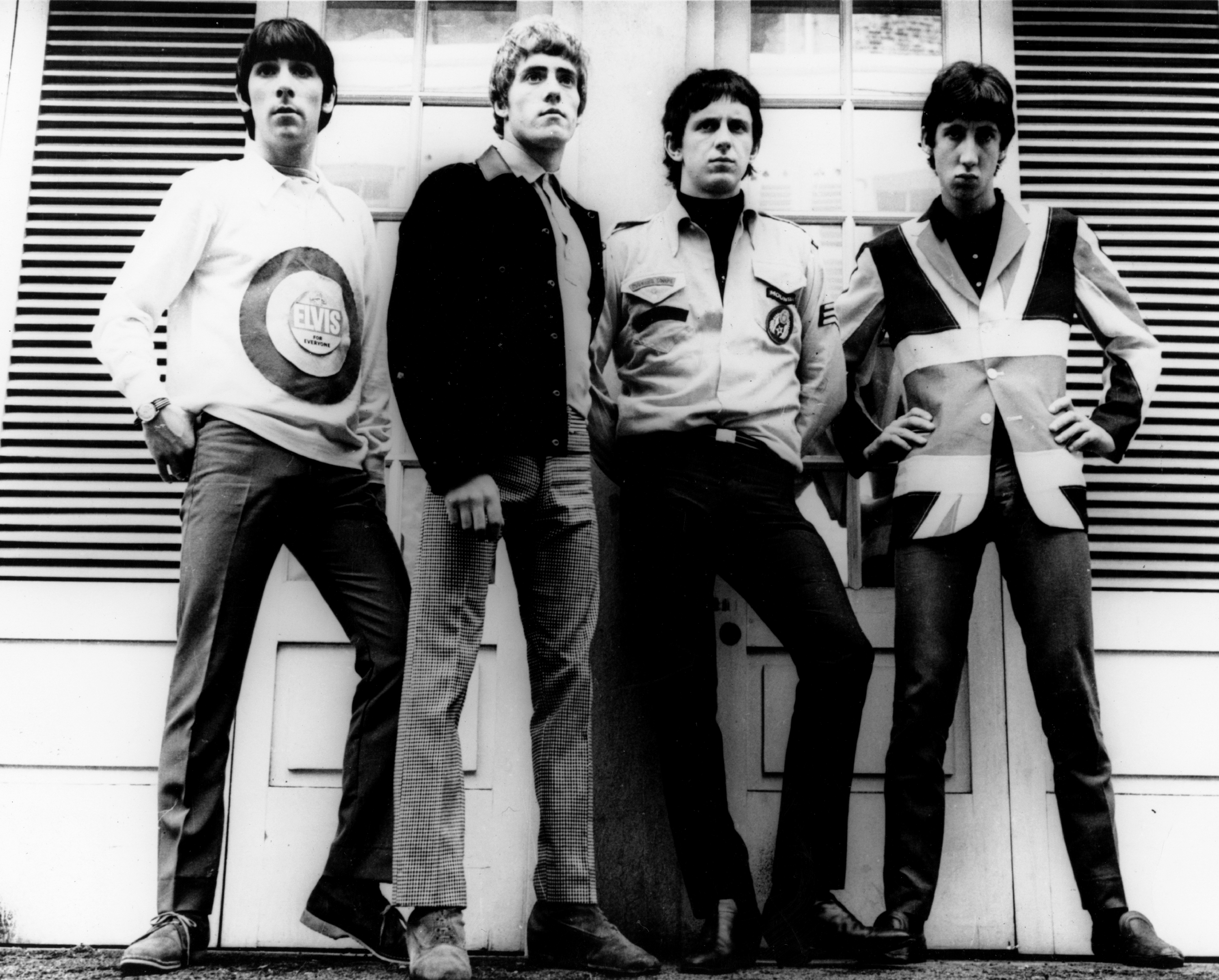 Keith Moon, Roger Daltrey, John Entwistle, and Pete Townshend of The Who standing in front of a wall