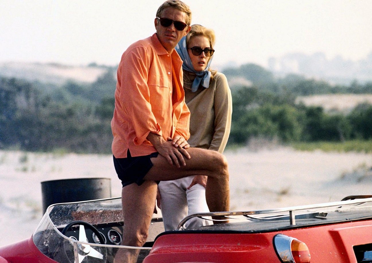 Steve McQueen and Faye Dunaway posing in an open-top car in a publicity image issued for the film, 'The Thomas Crown Affair.'
