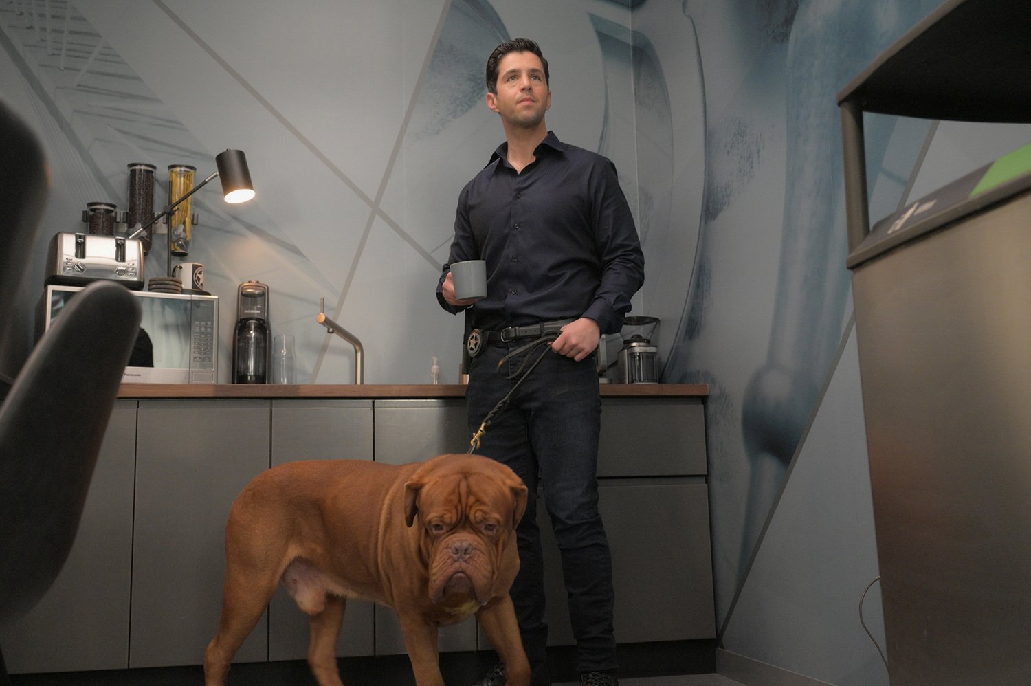 'Turner & Hooch' star Josh Peck holds a mug of coffee and stands beside a French mastiff dog