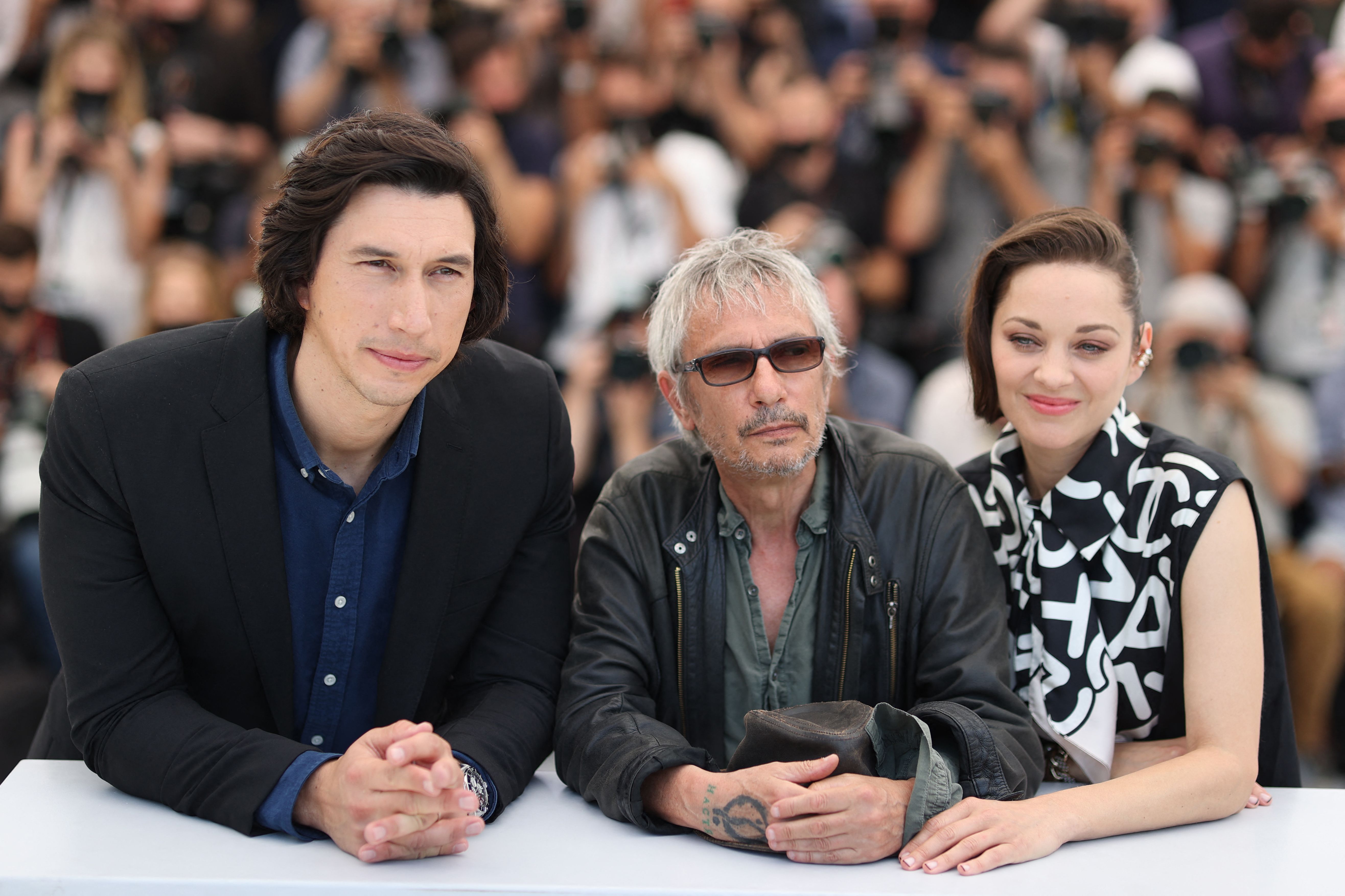 Adam Driver, Leos Carax, and Marion Cotillard pose during a photocall for the film "Annette" at the 74th edition of the Cannes Film Festival