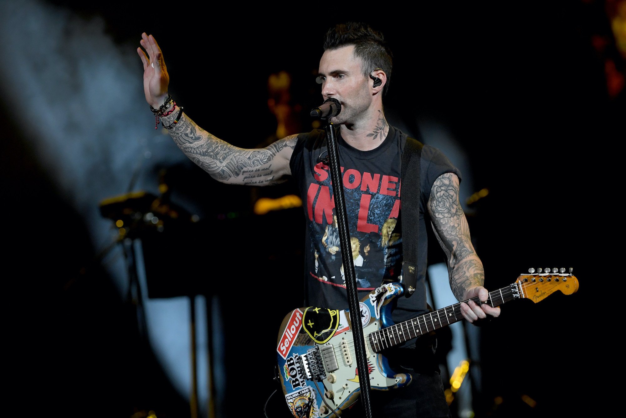 Adam Levine on stage, waving at a crowd