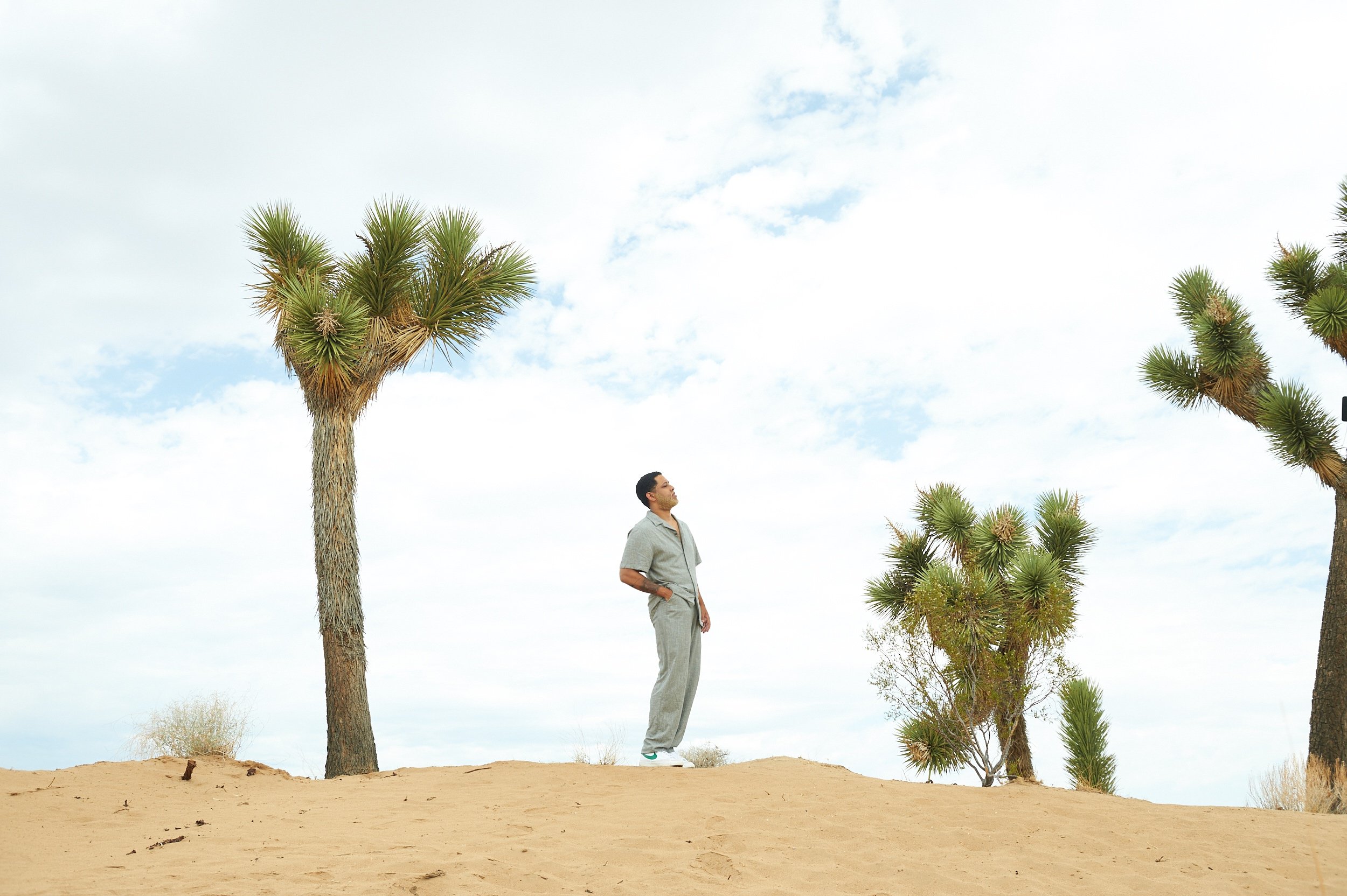 Singer-songwriter Alexander Nate stands in the middle of a desert