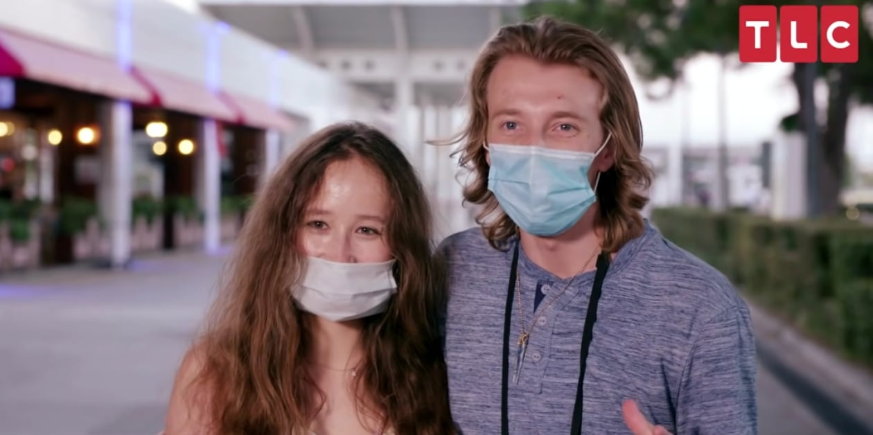 Alina and Steven with a v on 90 Day Fiancé, wearing face masks and facing the camera