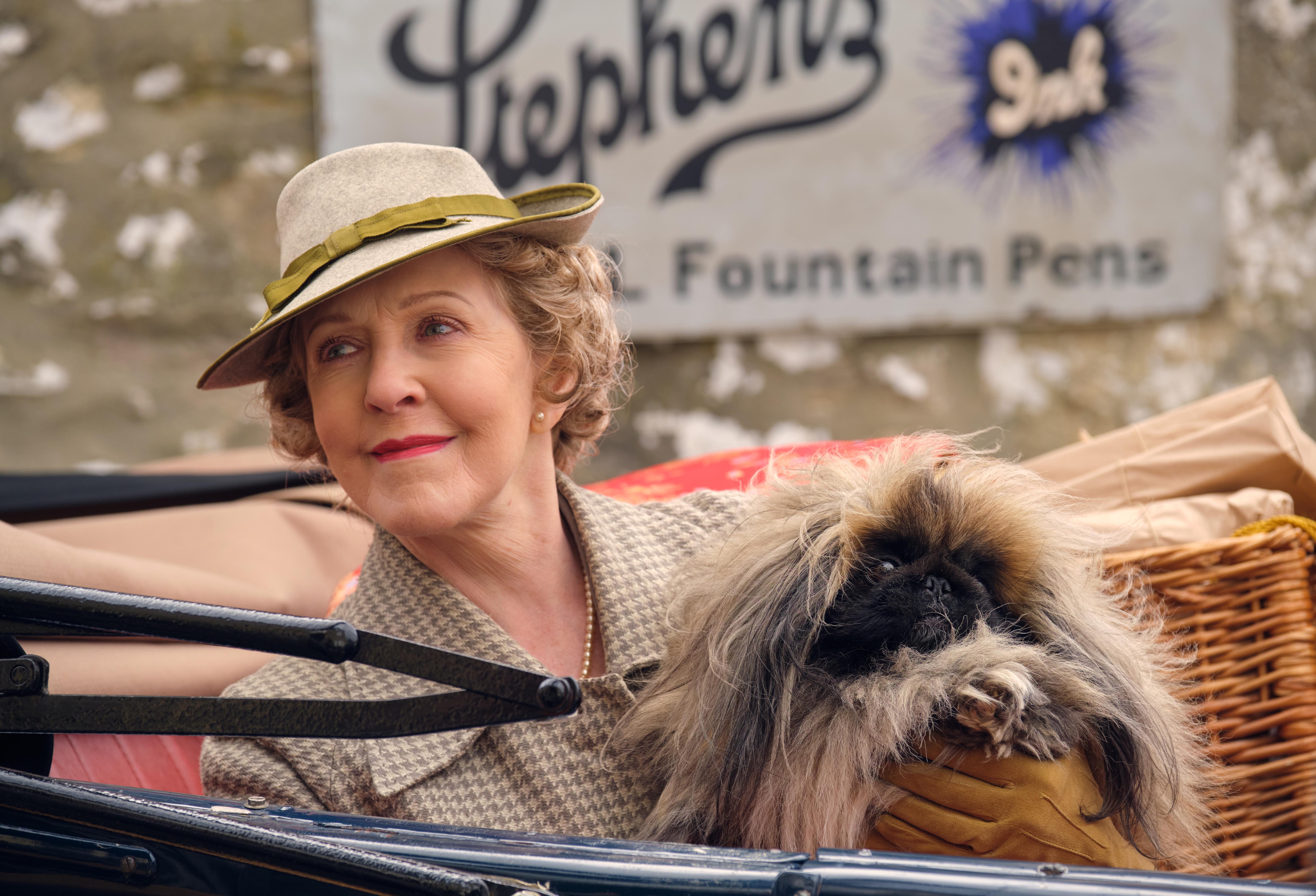 Mrs. Pumphrey holding Tricki Woo in a car in 'All Creatures Great and Small' Season 2