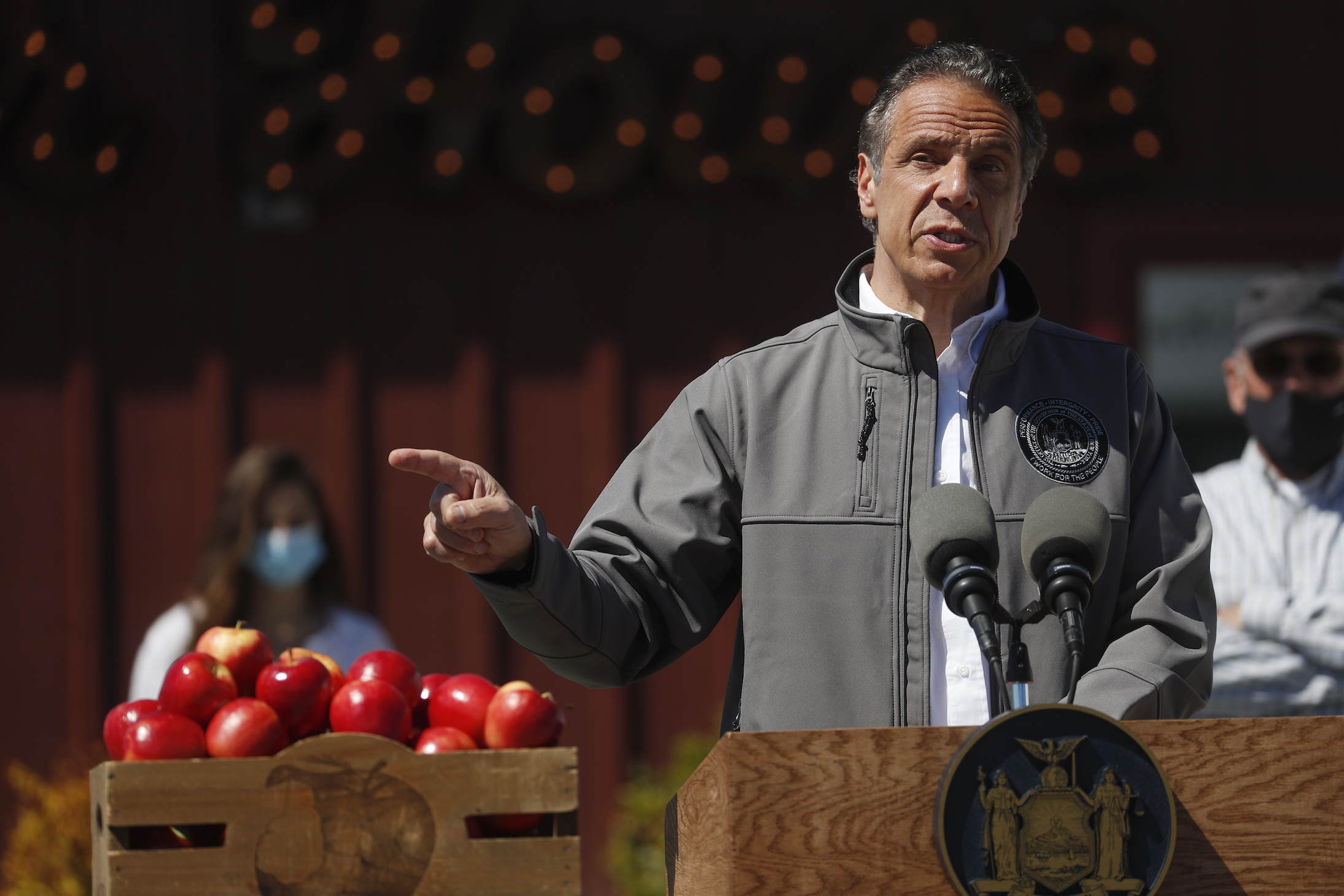 New York Governor Andrew Cuomo speaking at an event with a box of apples next to him