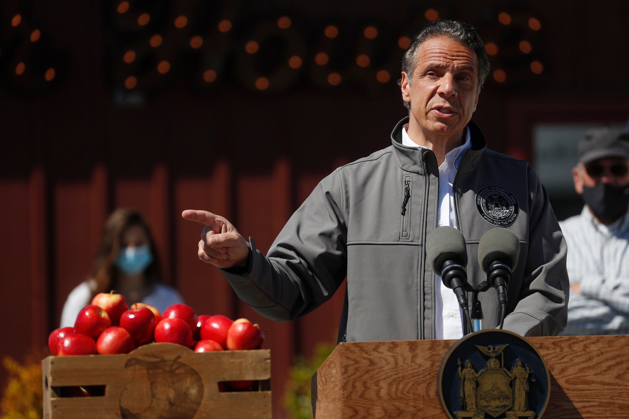 New York Governor Andrew Cuomo speaking at an event with a box of apples next to him