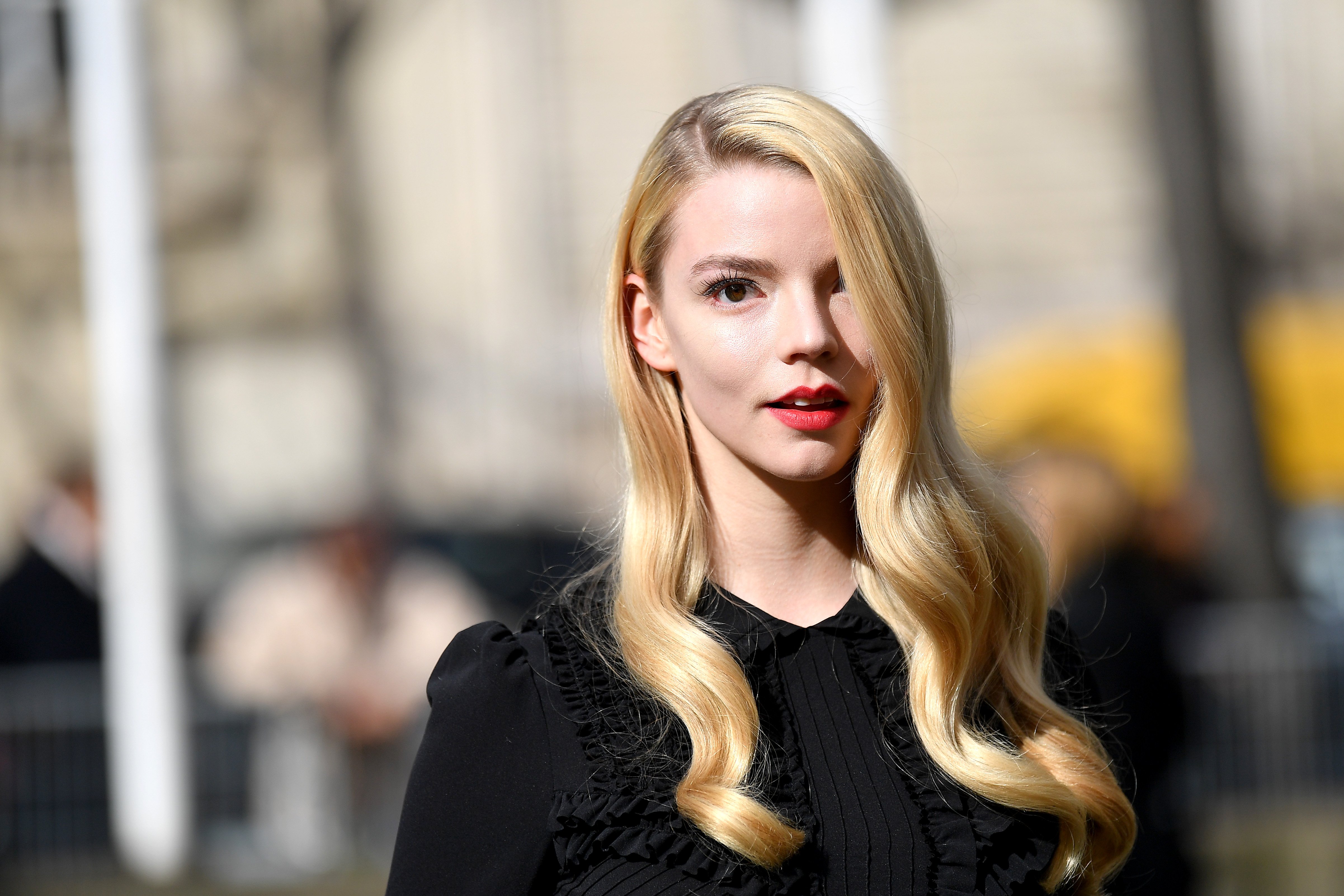 Anya Taylor-Joy in a black shirt with long blonde hair covering one eye.