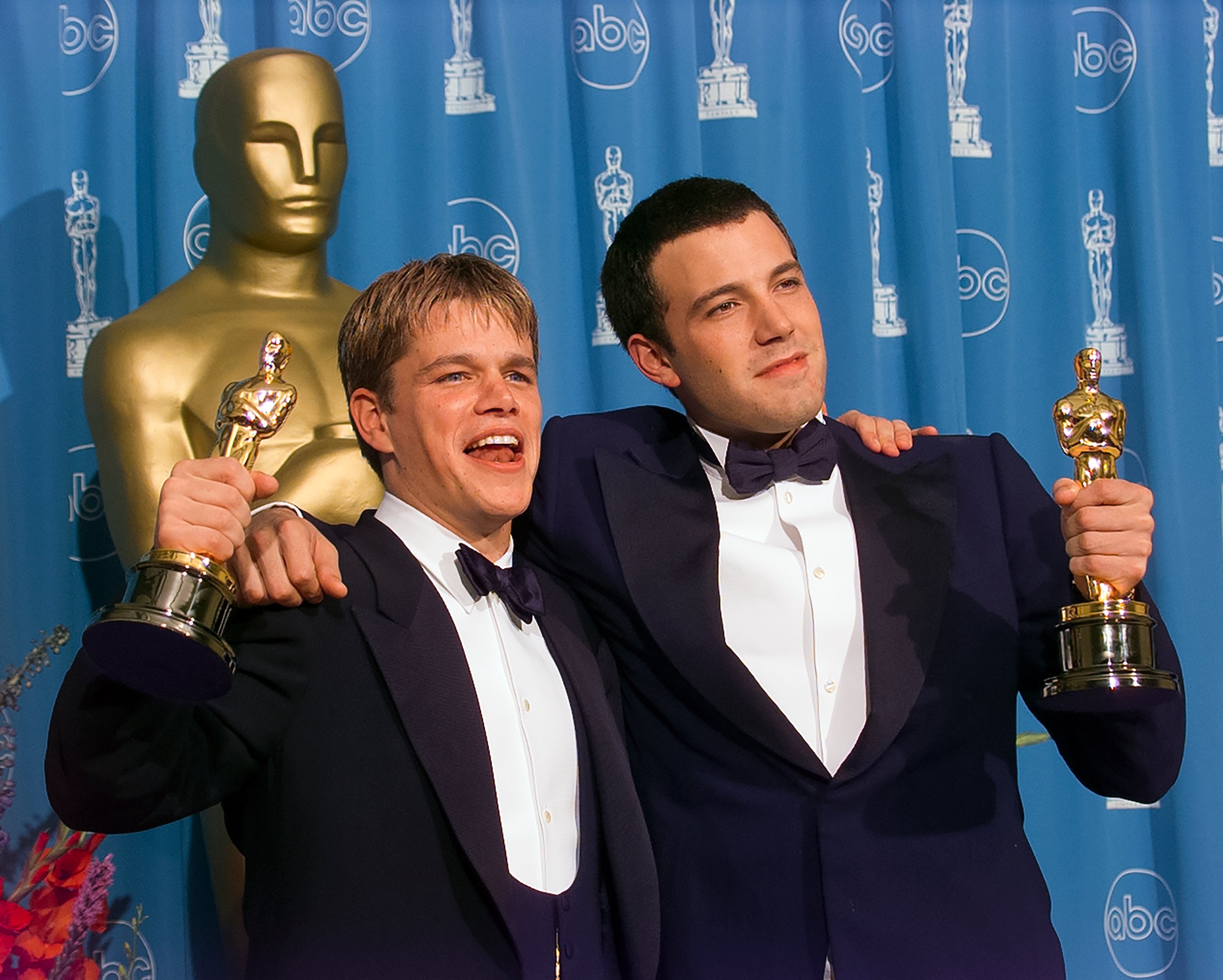 Matt Damon and Ben Affleck embracing each other while accepting their Oscars for 'Good Will Hunting.'