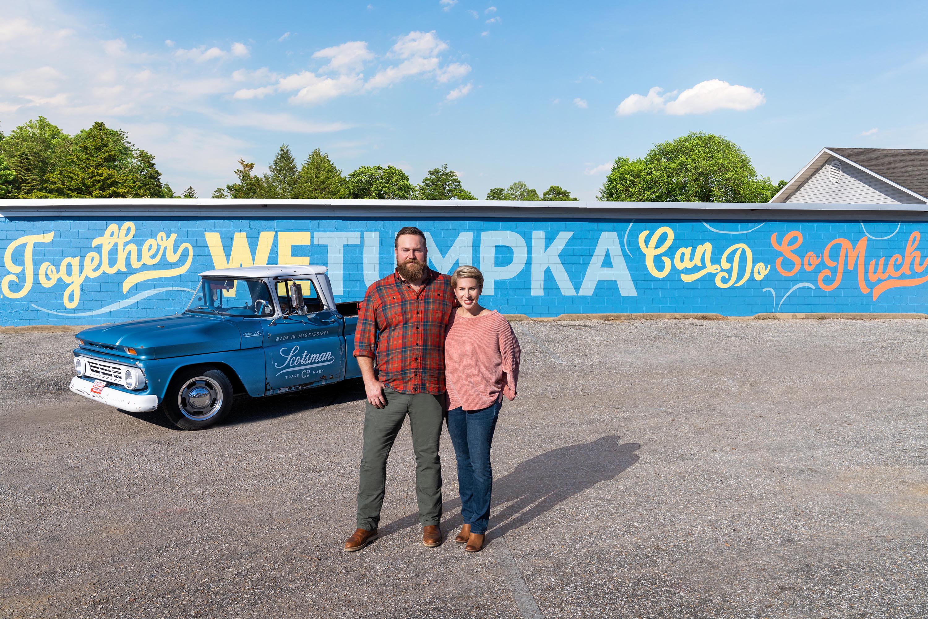 As seen on 'Home Town Takeover,' Ben and Erin Napier pose with the Scotsman Chevrolet in front of the Wetumpka signage in downtown Wetumpka, Alabama.