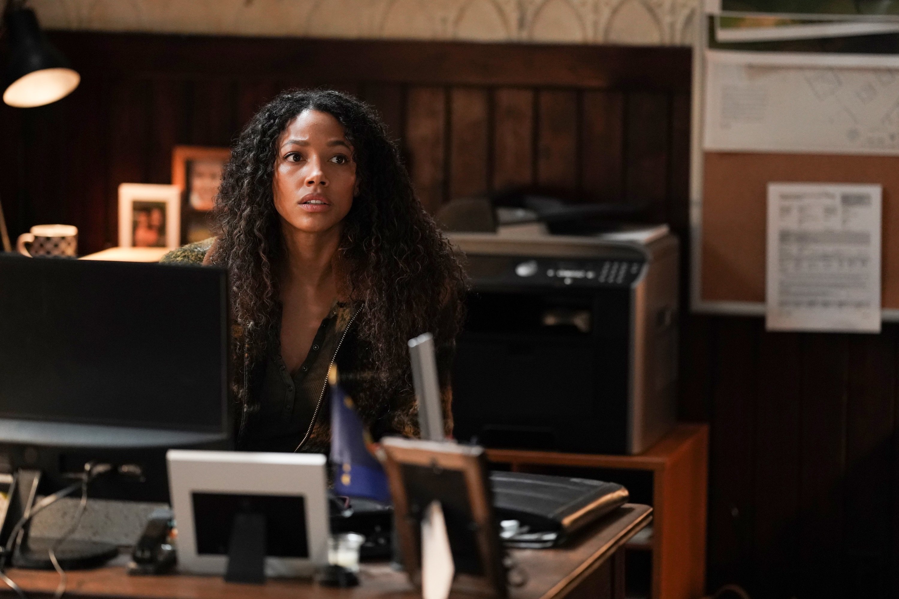 Big Sky Season 1 Kylie Bunbury portrays Cassie Dewell sitting at a desk looking worried.