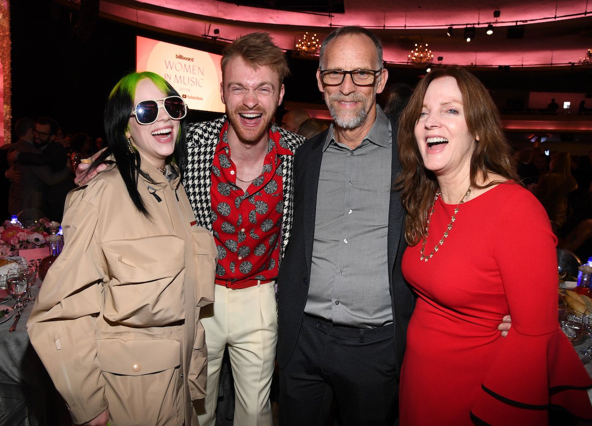 Billie Eilish, Finneas O'Connell, and their parents Patrick O'Connell and Maggie Baird smiling at the camera.