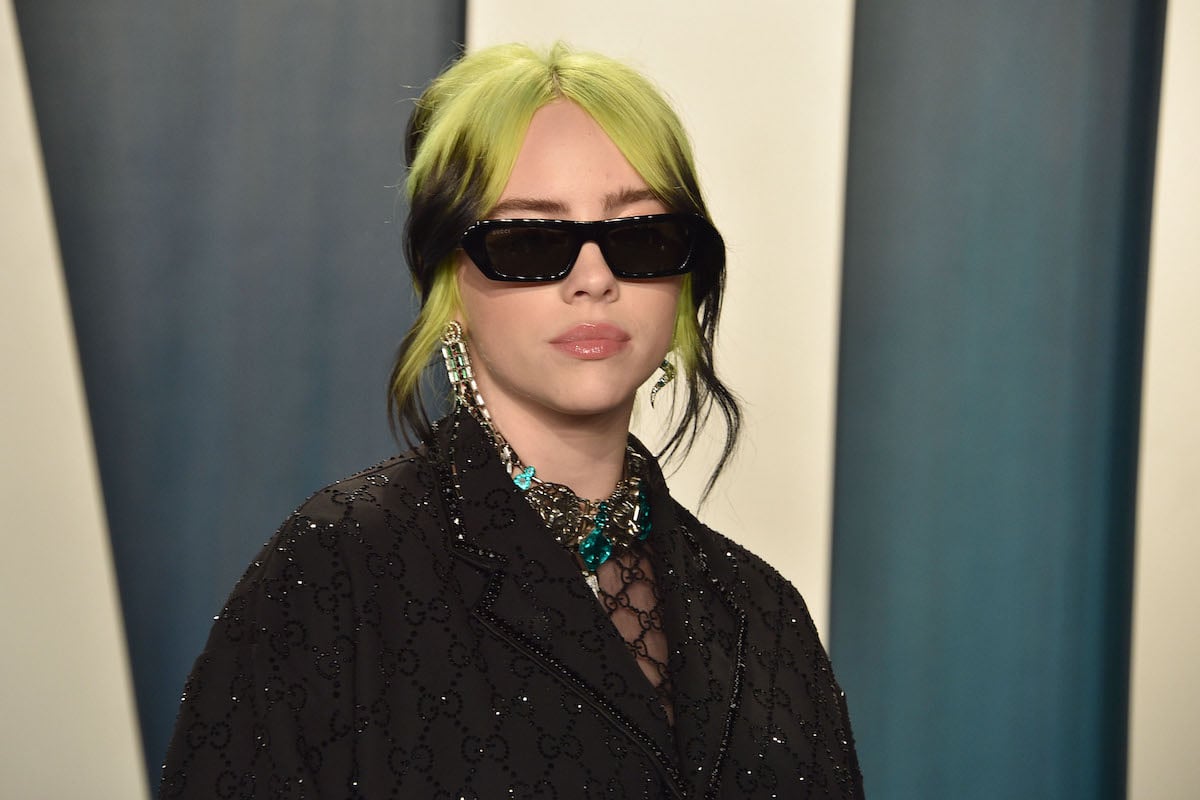 Billie Eilish wearing a black outfit and black sunglasses.