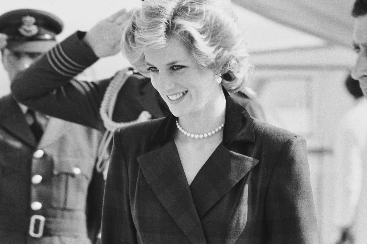 Black-and-white photo of Princess Diana in 1985 wearing an outfit designed by Catherine Walker, with pearl earrings and a pearl necklace