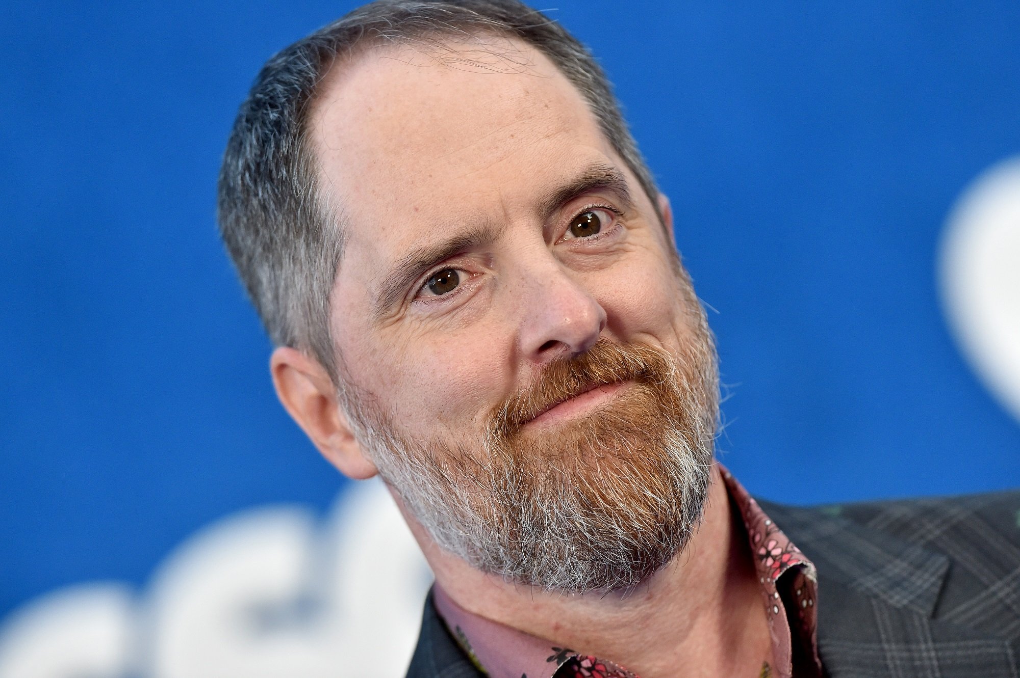 Brendan Hunt in front of a blue background while attending the season 2 premiere of 'Ted Lasso'