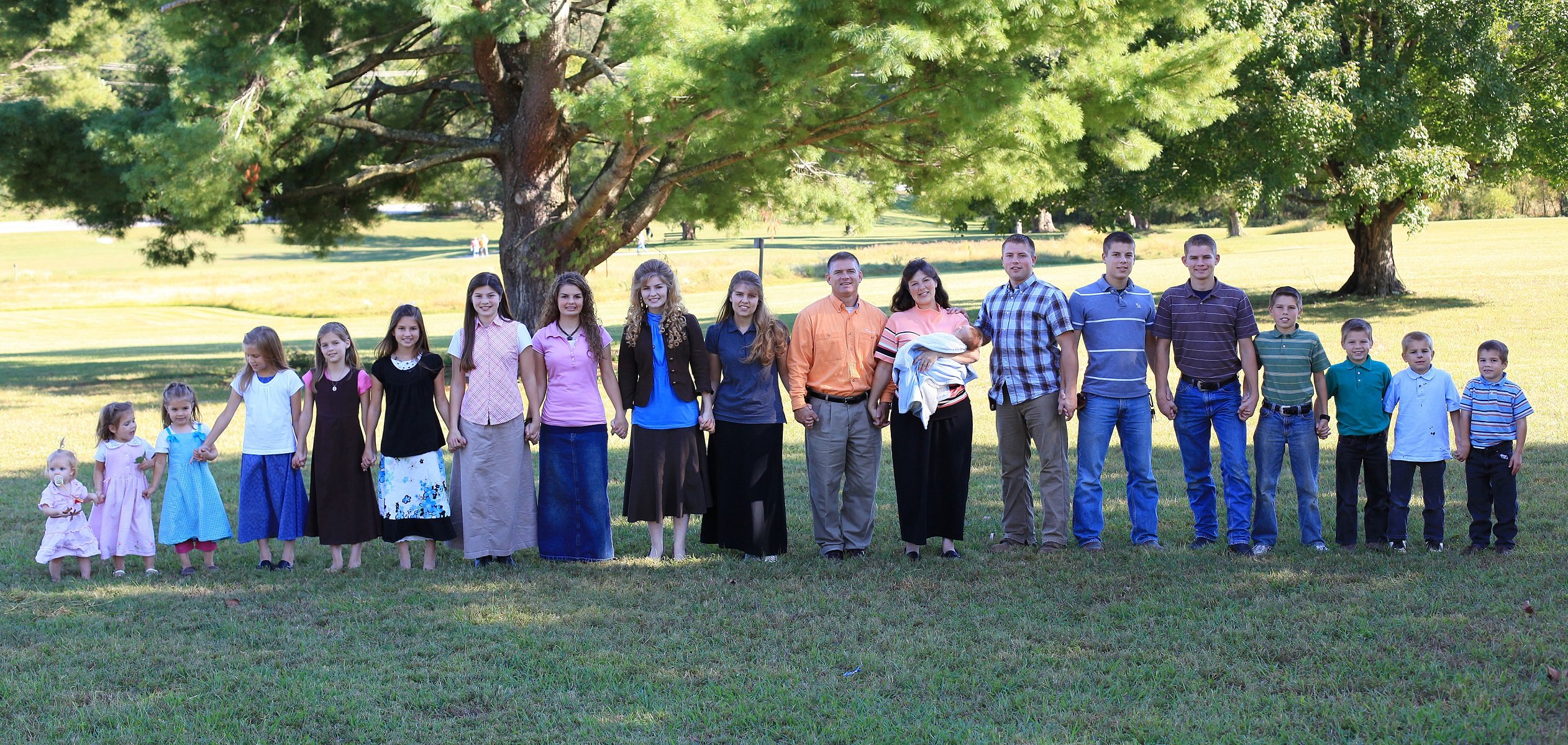 The Bates family stands together on their Tennessee property for a promotional photo.