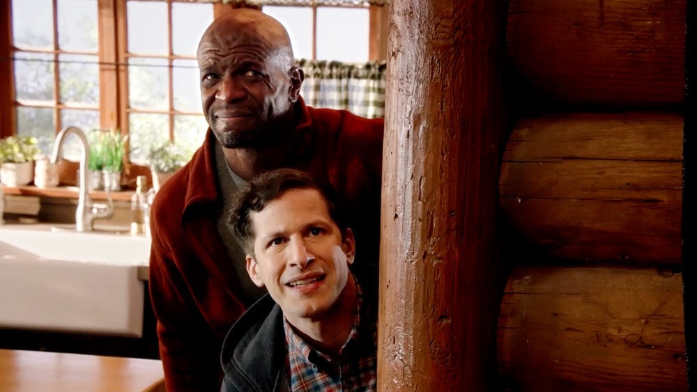 Terry Jeffords and Jake Peralta cringe while hiding behind a wall in 'Brooklyn Nine-Nine'
