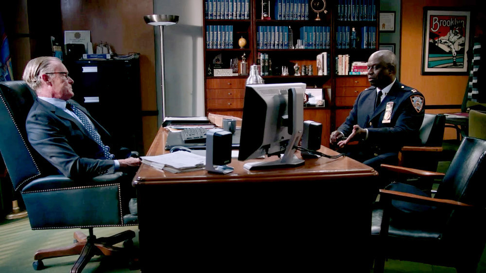 Frank O'Sullivan and Captain Ray Holt sit at a desk in season 8 of 'Brooklyn Nine-Nine'