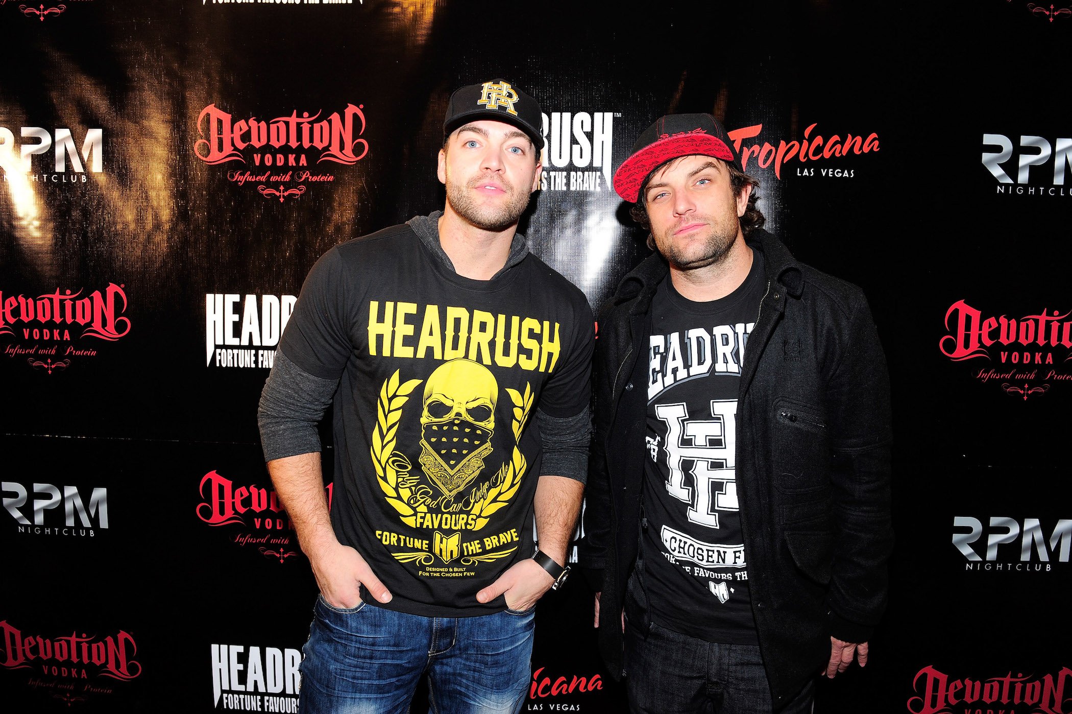 CT Tamburello and T.J. Lavin from MTV's 'The Challenge' Season 37 standing next to each other at an event against a dark background