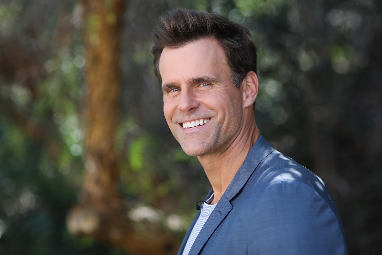 Cameron Mathison smiling in front of trees