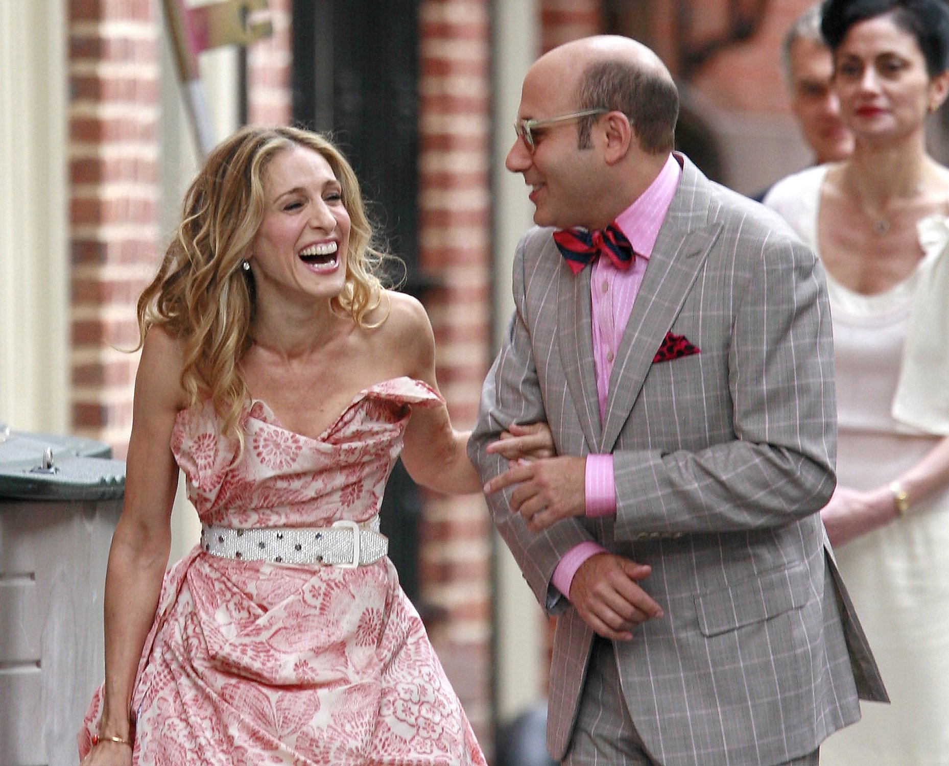 Carrie Bradshaw and Stanford Blatch laugh as they walk down a Manhattan sidewalk for a scene in 'Sex and the City: The Movie'
