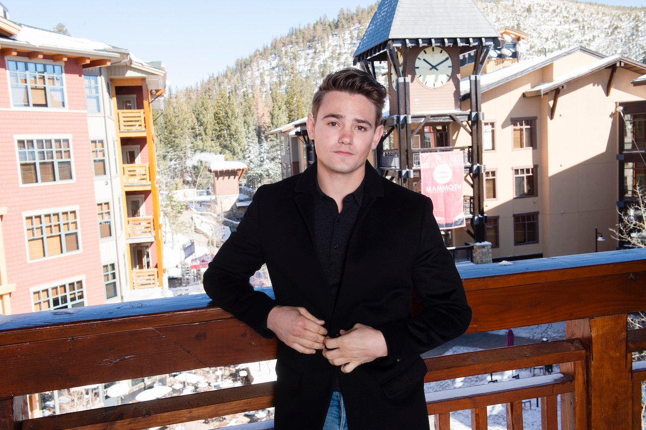 Carson Boatman standing against a railing with houses in the background