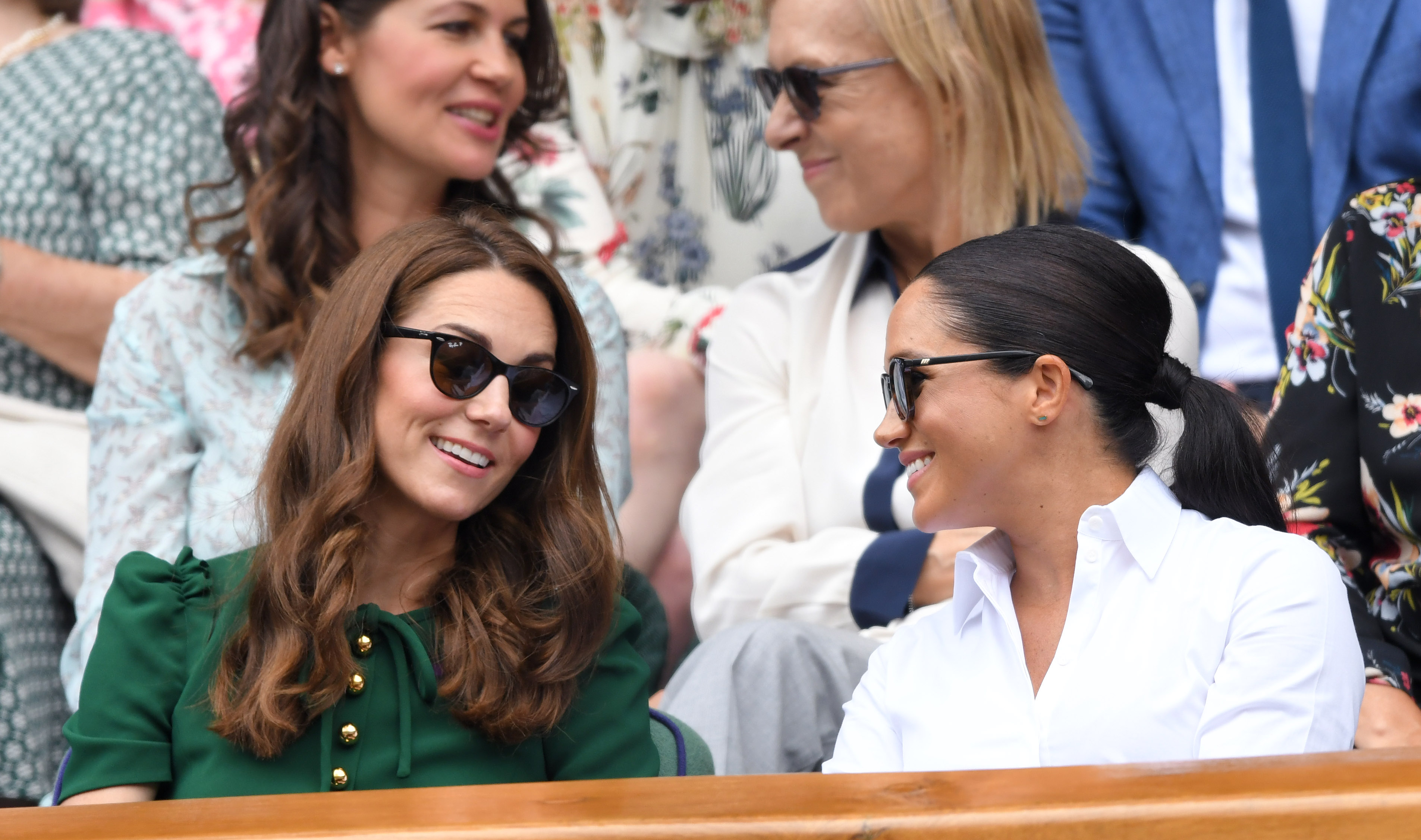 Kate Middleton and Meghan Markle talking at tennis match